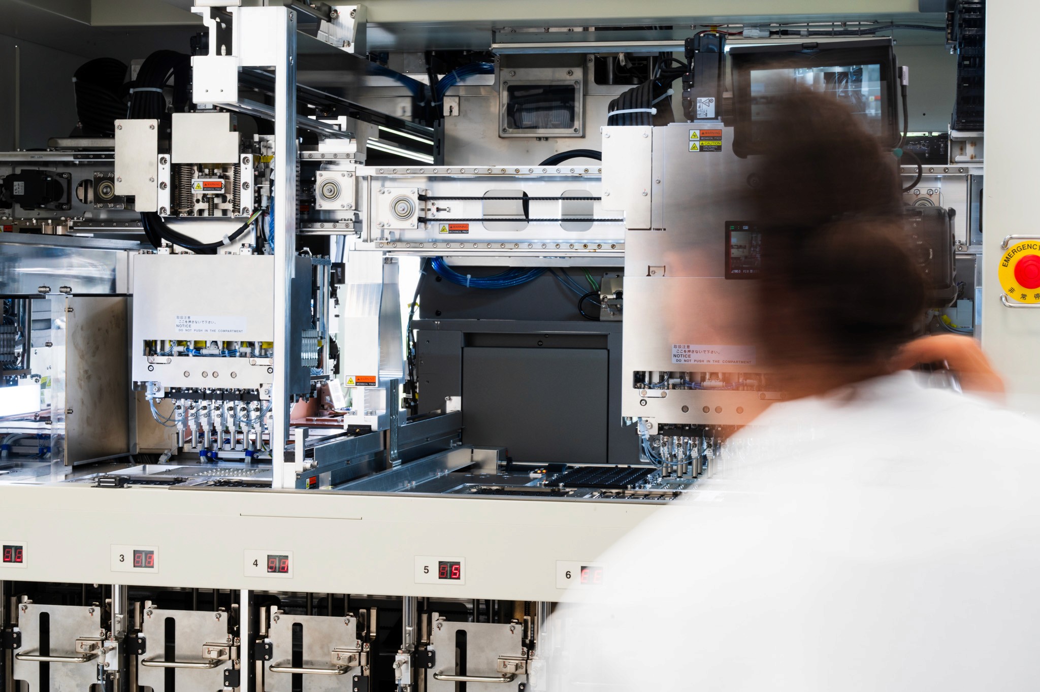 Tehnician lucrând la o mașină de testare a semiconductorilor