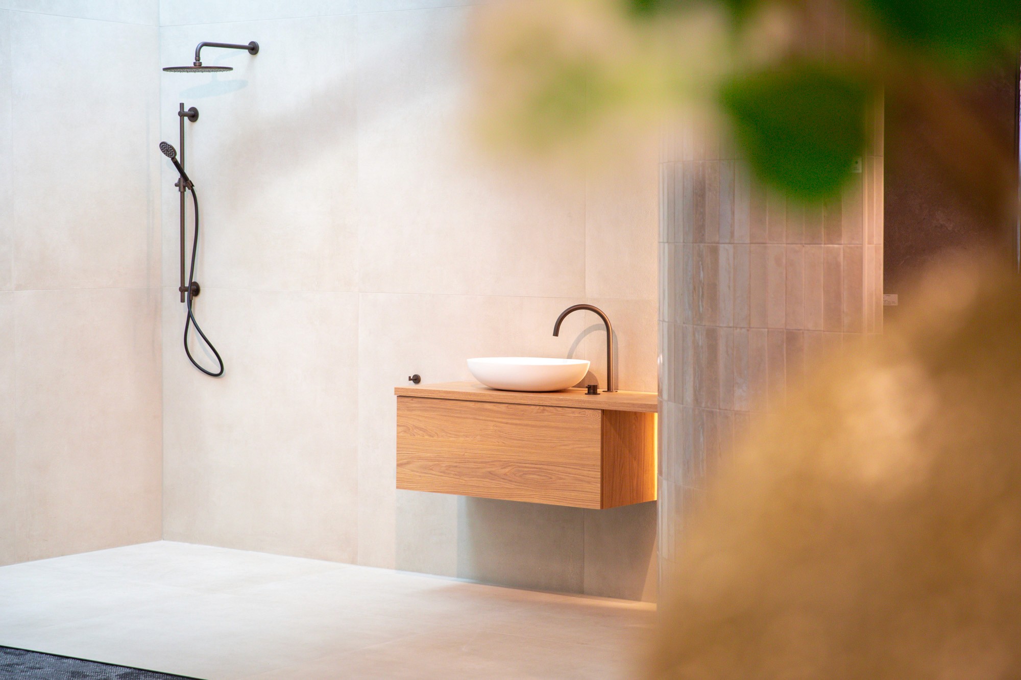 Modern interior space with a blue circular coffee table, flowers in a vase, and books neatly arranged.