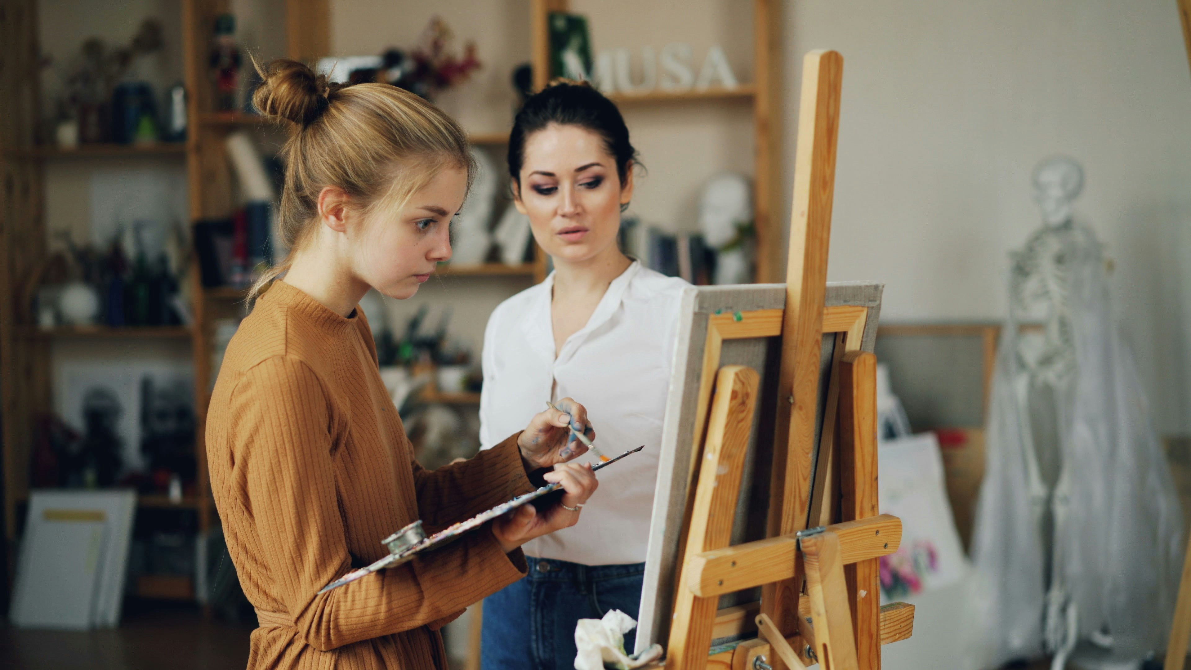Artist and teacher discuss painting in the studio.