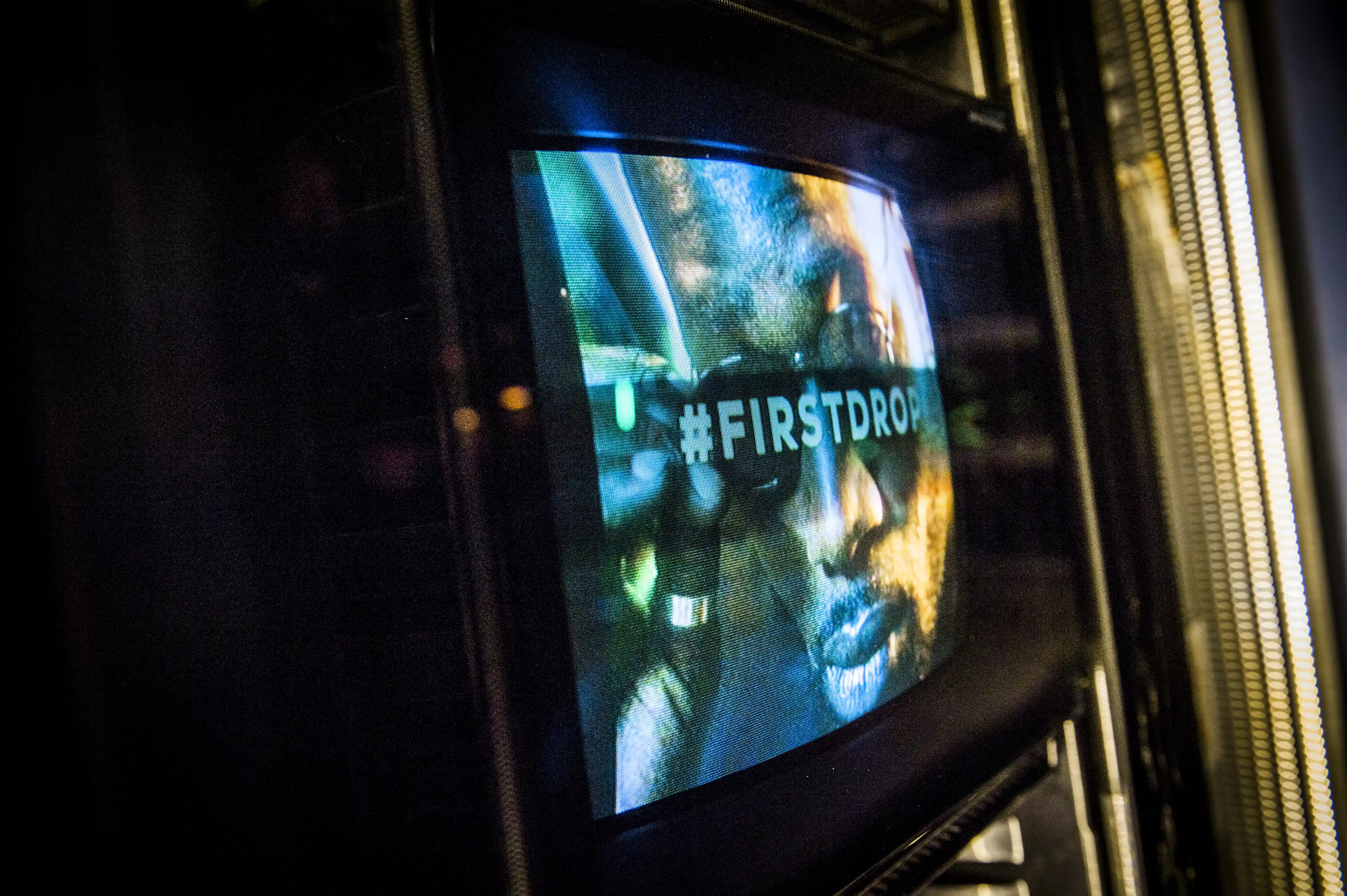 Tube TV inside a fridge display showing a #FIRSTDROP campaign visual at the JÄGERMEISTER streetwear launch.