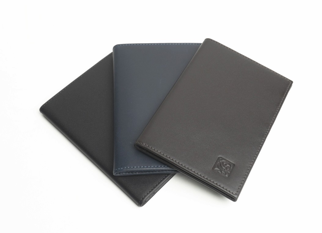 Three smooth leather passport wallets arranged in a fan shape, in black, blue, and dark brown.