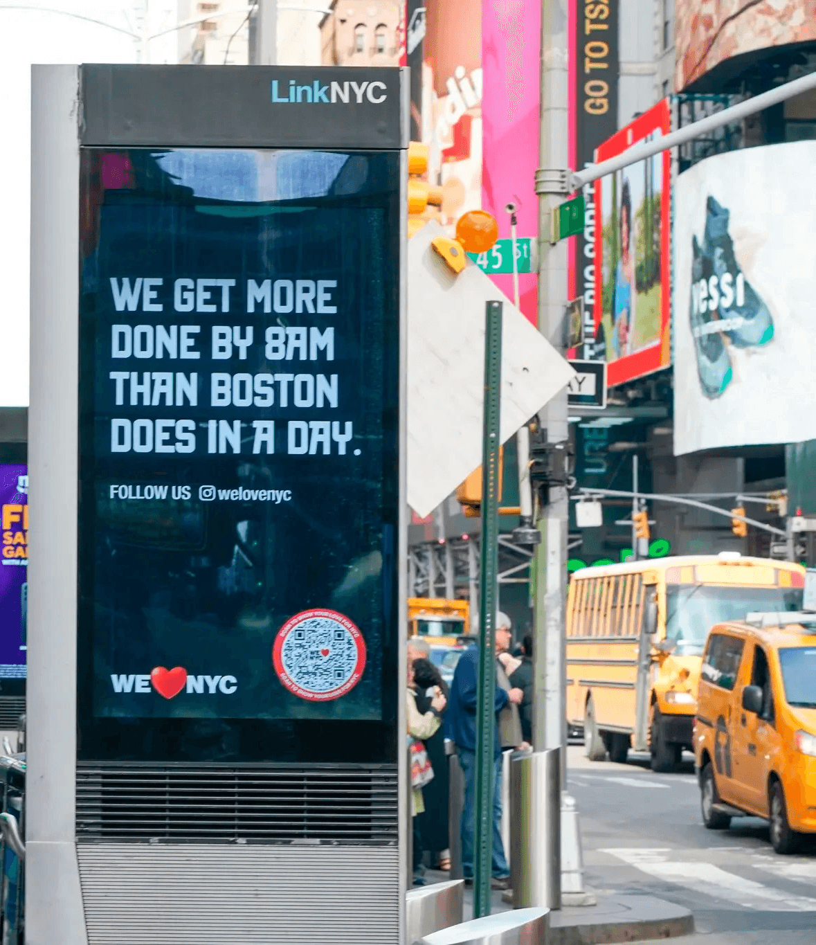 Digital ad on an outdoor LinkNYC street kiosk that reads "We get more done by 8am than Boston does in a day."