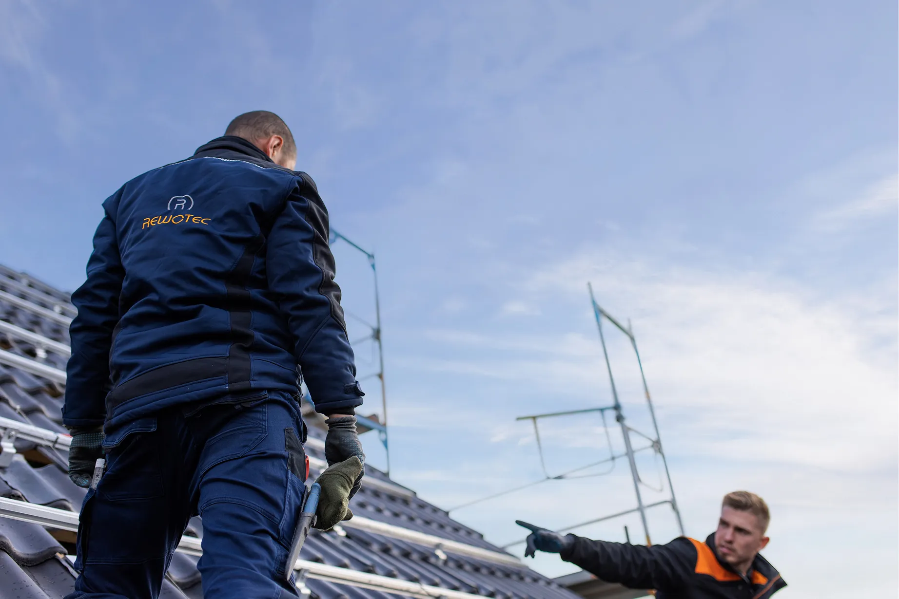 Zwei Monteure bei Arbeiten an einer PV-Anlage auf einem Hausdach