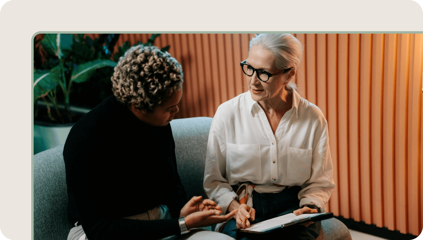 Two people discussing insights during a user research interview using a tablet.