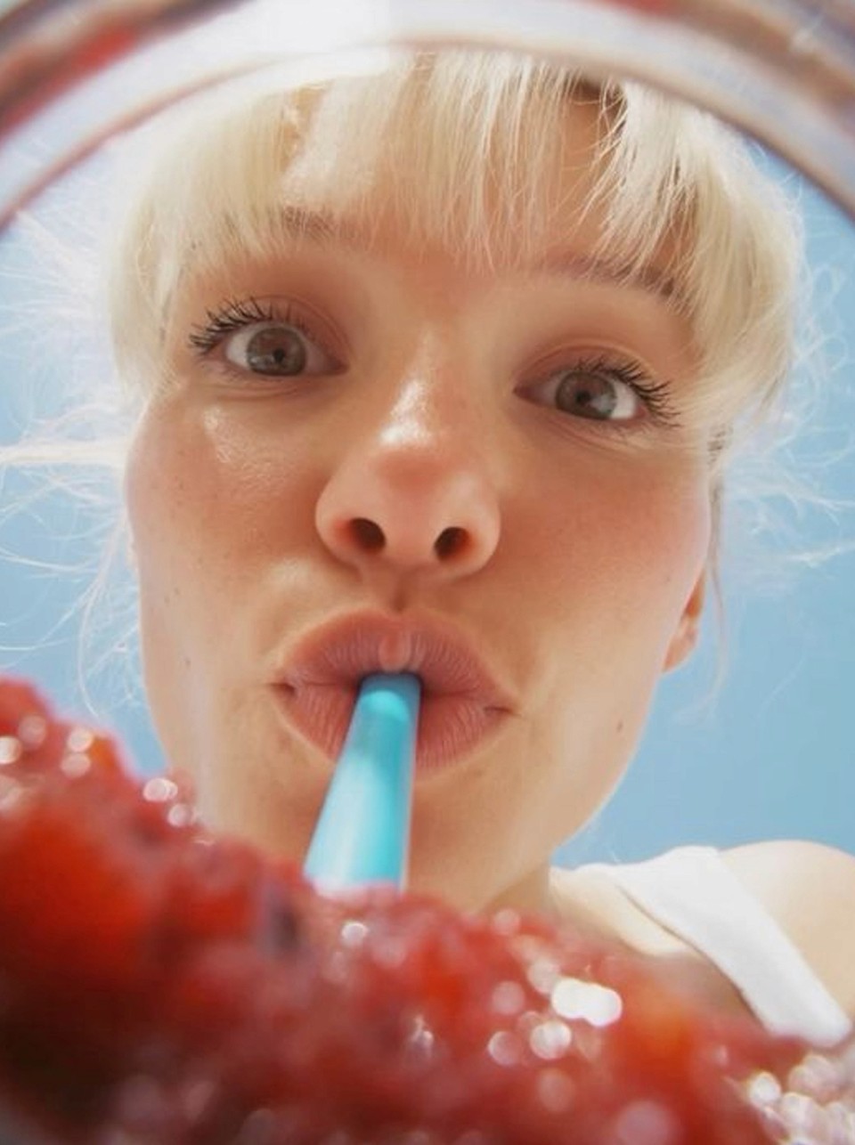 Two plates of pasta topped with herbs, crushed nuts, and a drizzle of sauce, set on a wooden table.
