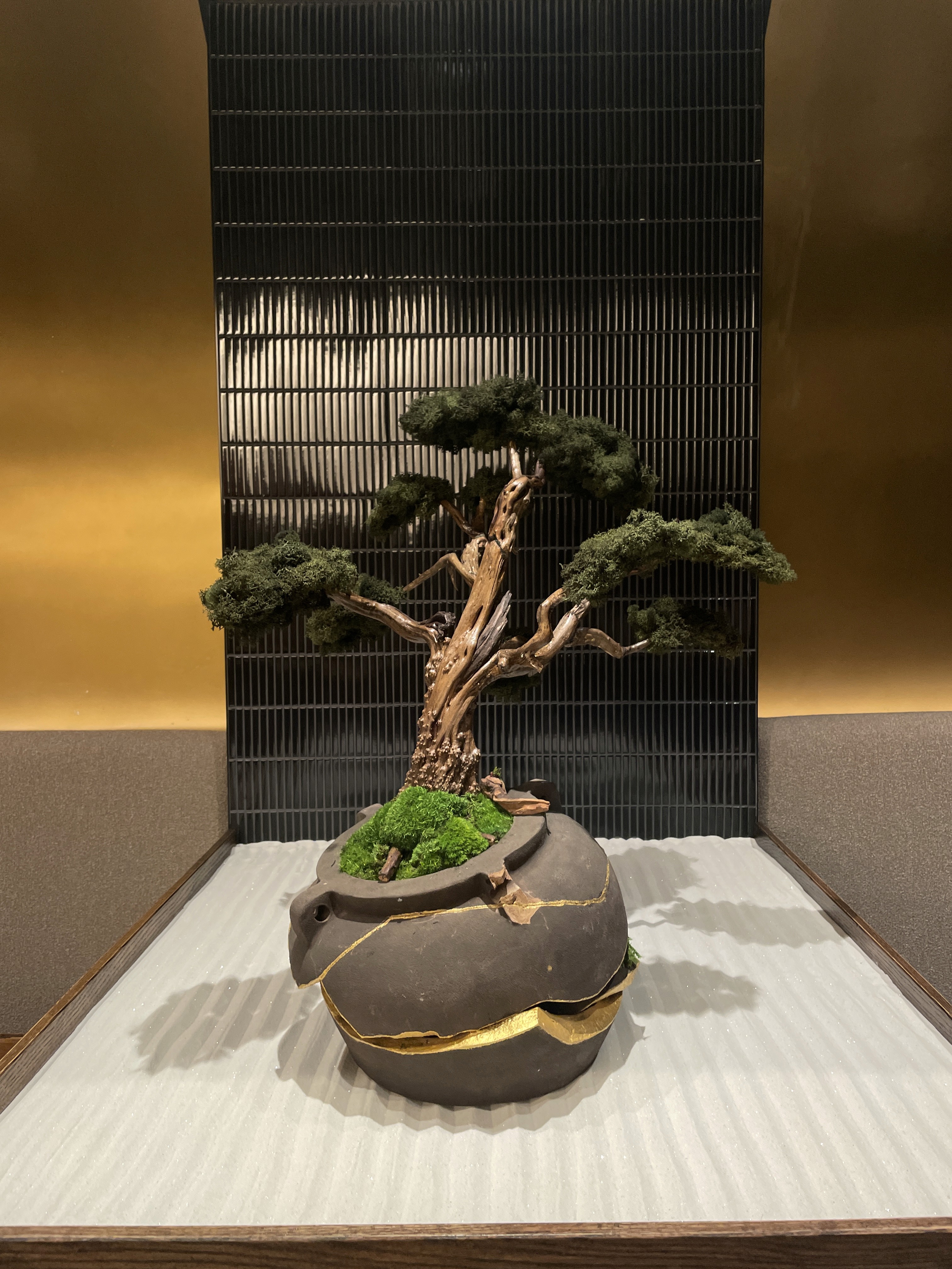 Architectual wood-furniture in front of plain grey wall