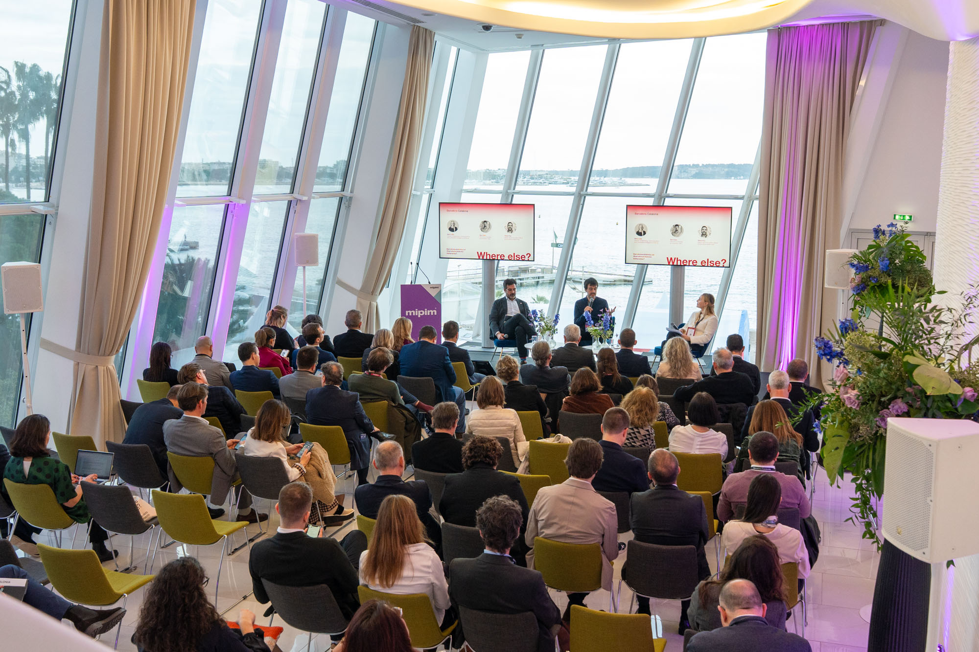 Collaborative work session overhead view of six people collaborating at a rustic wooden table with coffee, papers, and a laptop