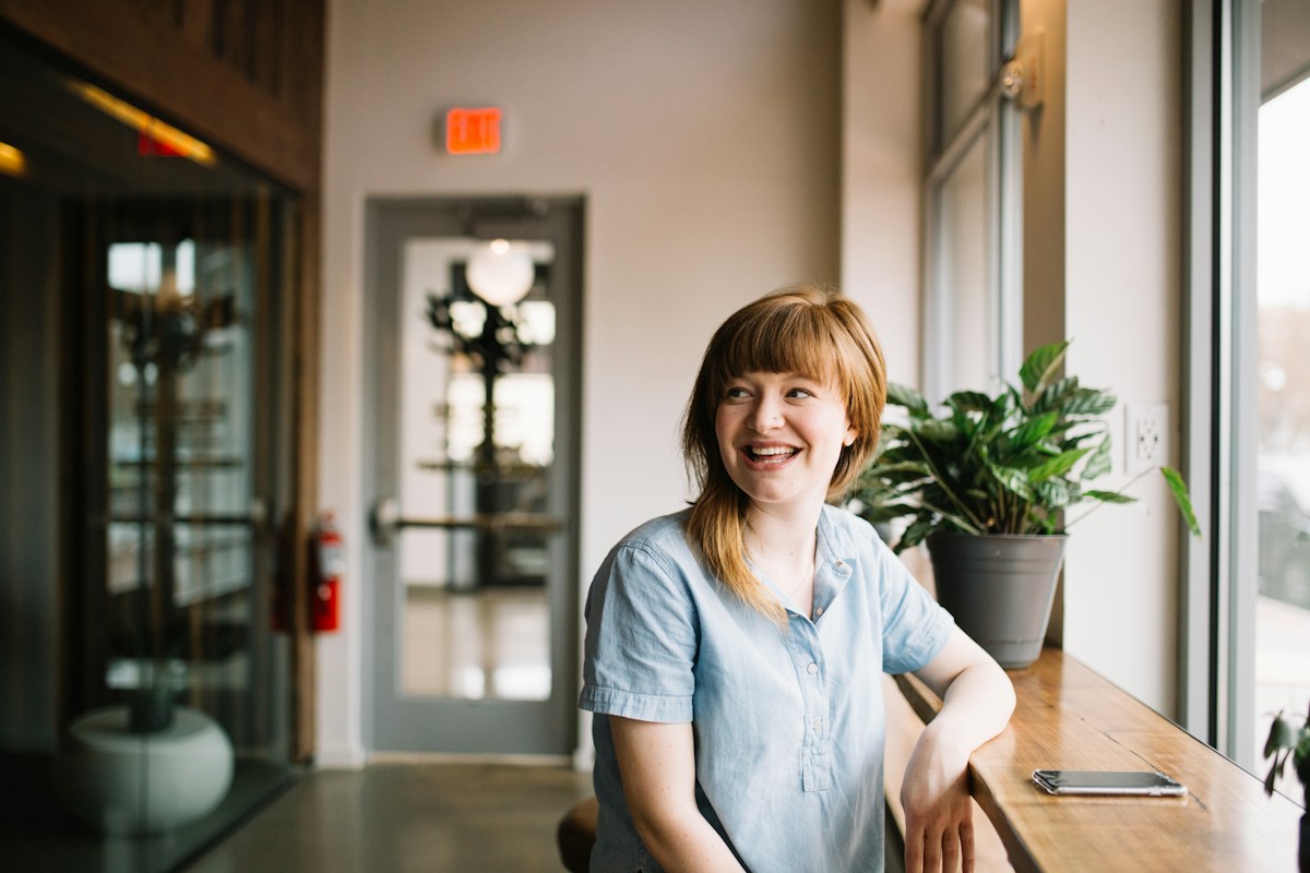 Woman smiling by the window of a studio