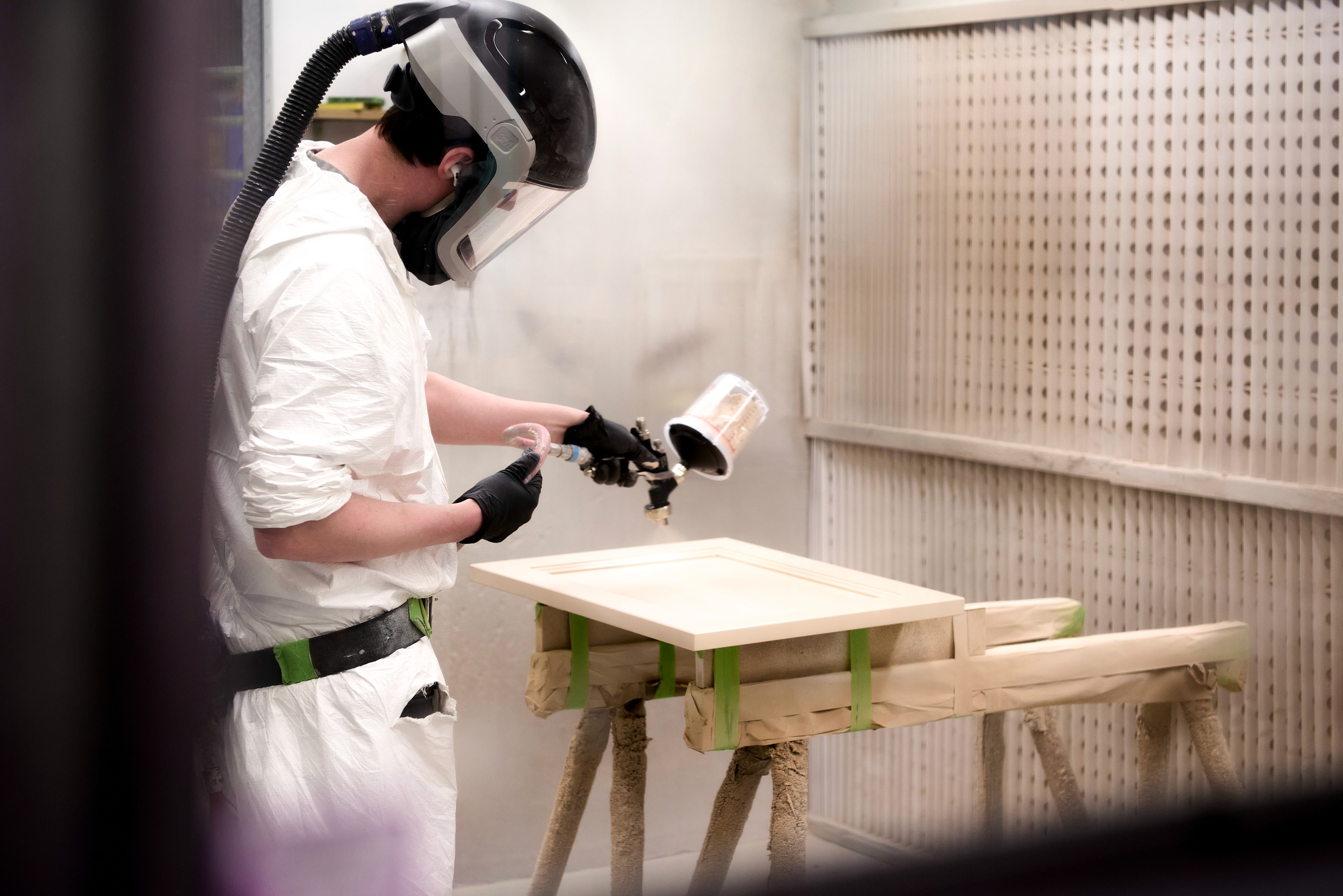 On-site workshop spray booth - wooden cabinet door being prepped and painted ready for assembly