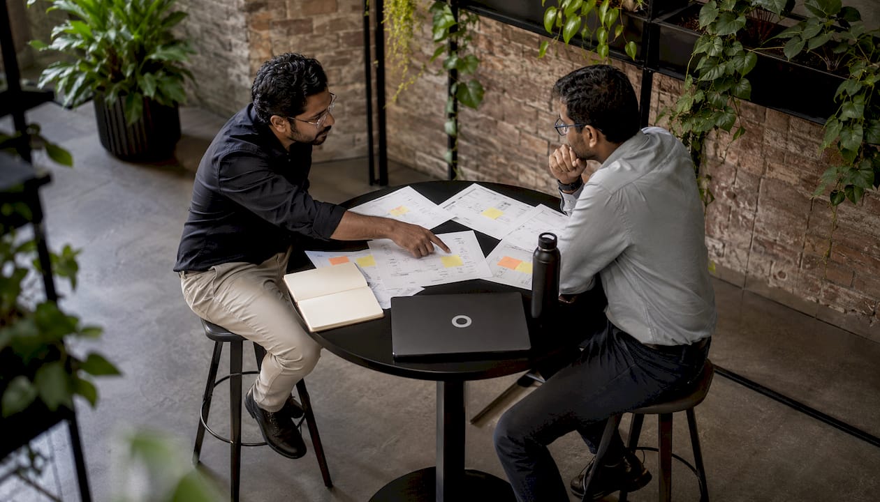 Two men discussing brand tracking survey questions