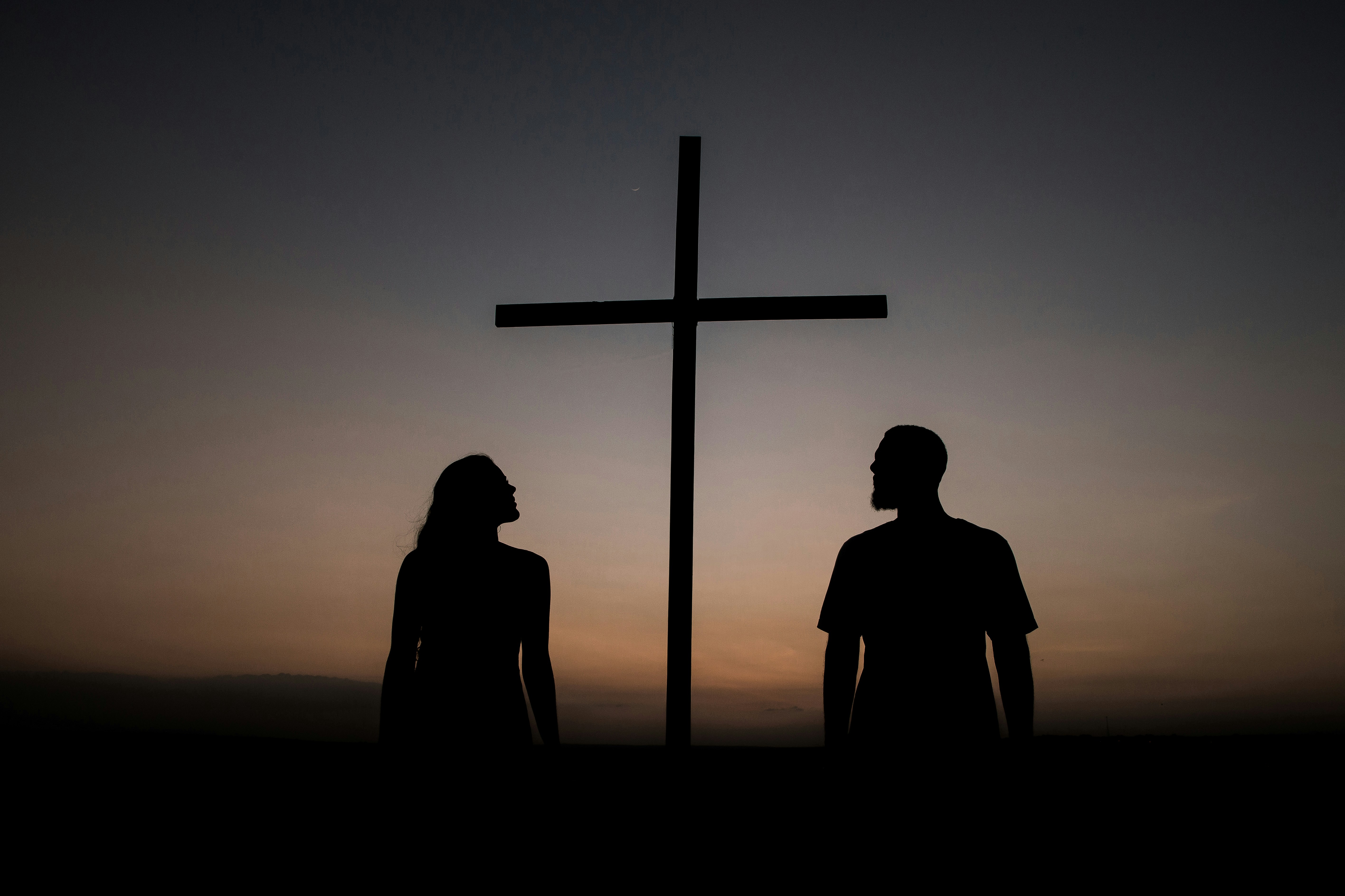 people standing next to a cross - how to write gospel songs