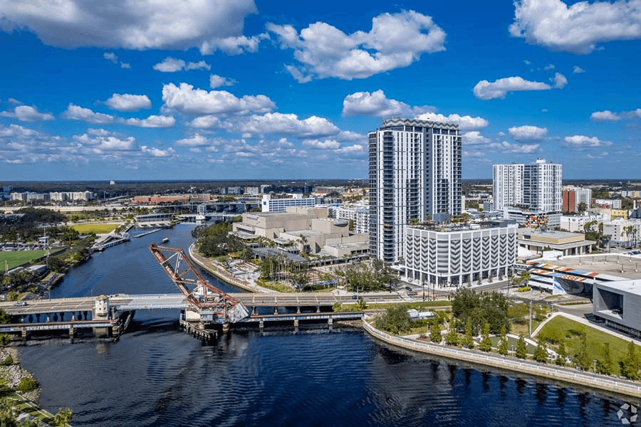 Waterfront view of AER Tampa building complex along river with landscape