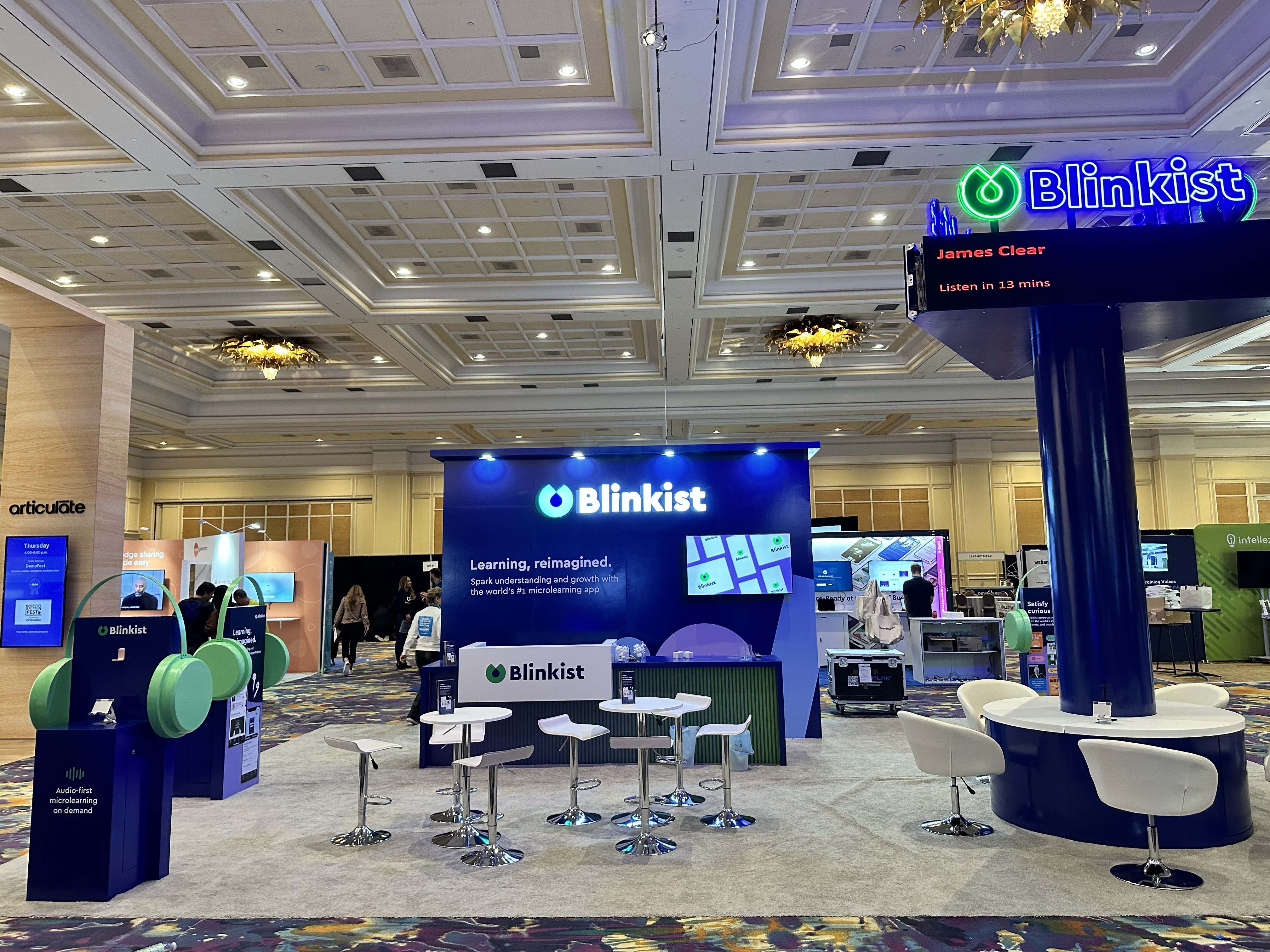 20x20 trade show booth with reception counter, meeting tables, and branded backdrop wall