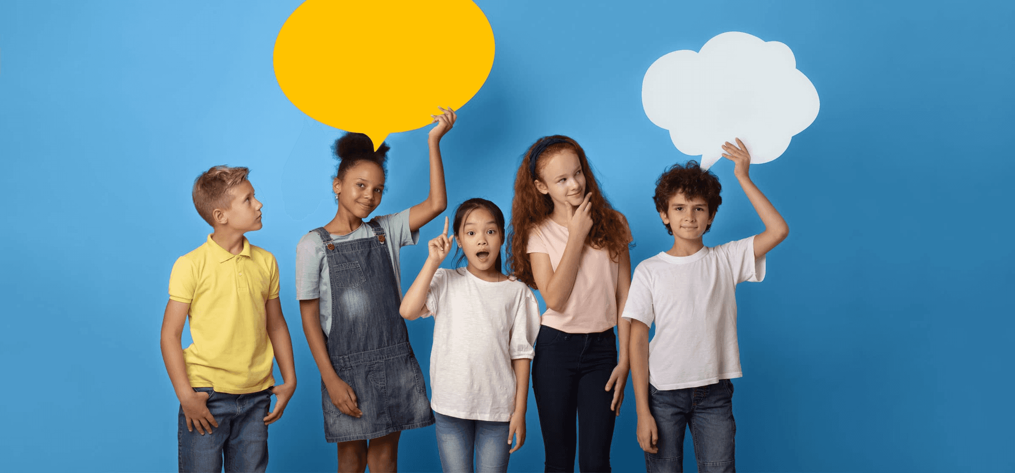 Group of five diverse children standing against a blue background, playfully holding colorful speech and thought bubbles to represent communication and self-expression.