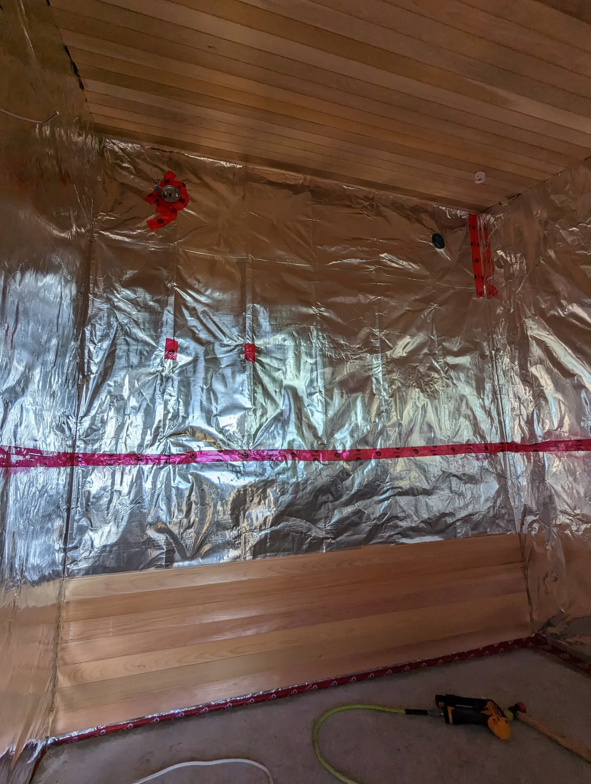 Modern two-story home with large glass windows, warmly lit interiors, and a balcony. Surrounded by trees and a manicured lawn at dusk. Cozy ambiance.