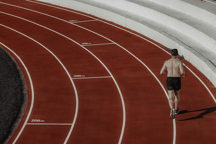 Runner on a track field viewed from above, minimal composition