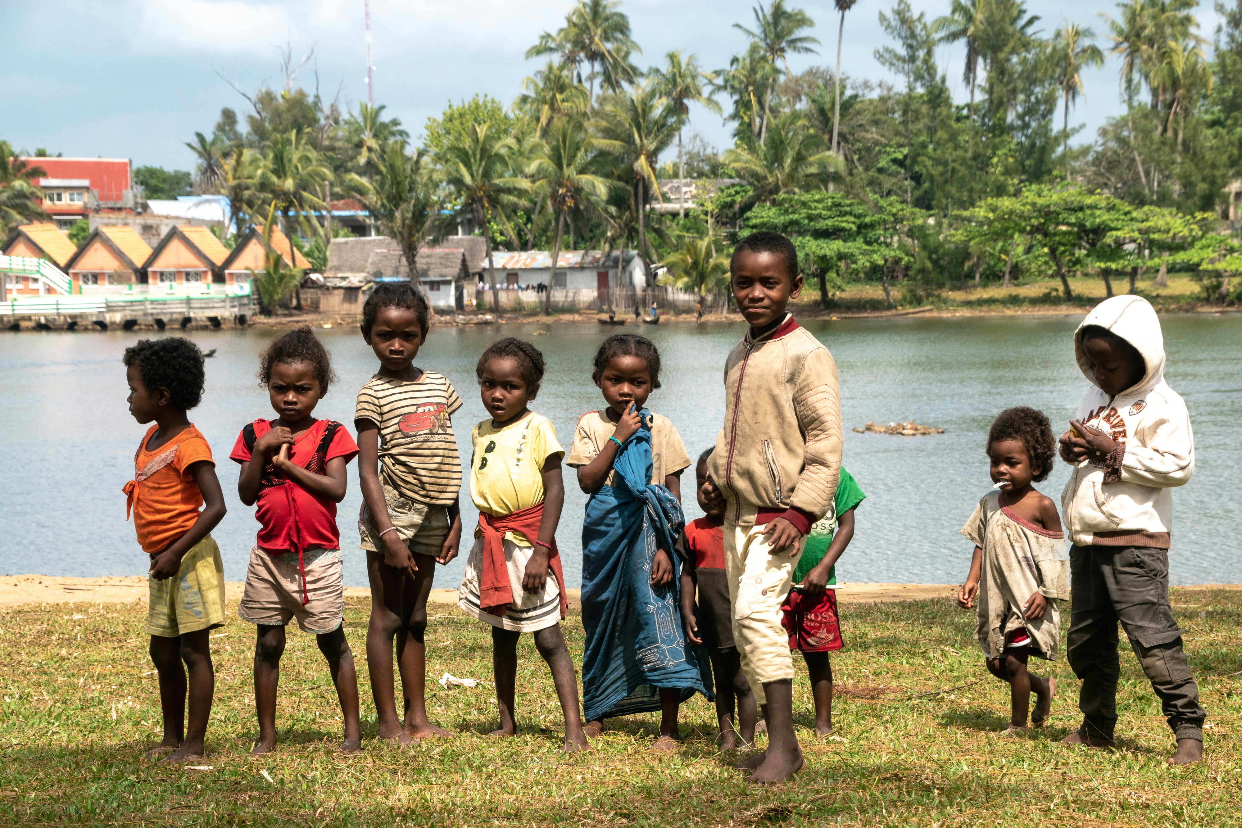 A group of children standing in front of a body of water