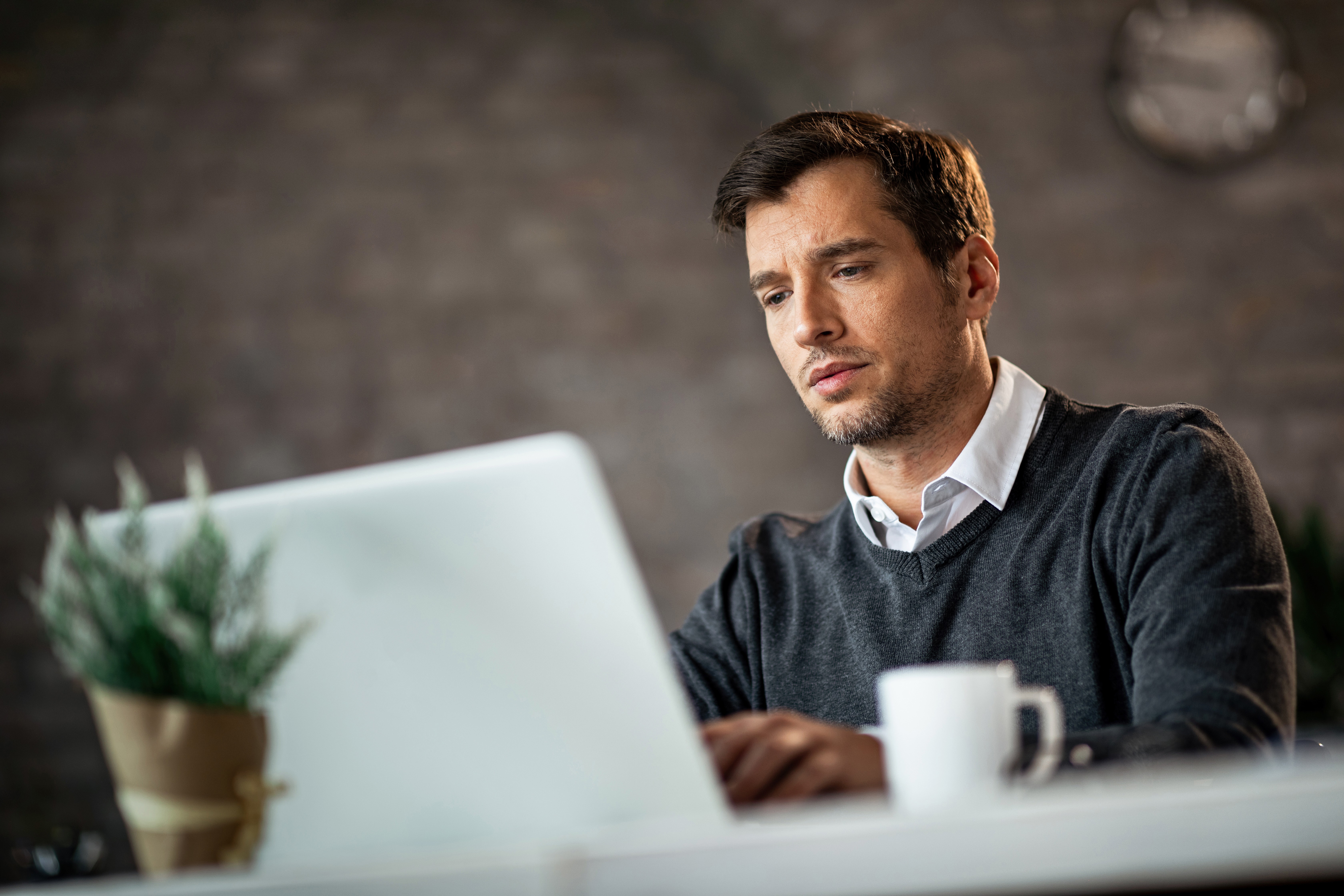 Professional working on a laptop, analyzing and managing a business or management system