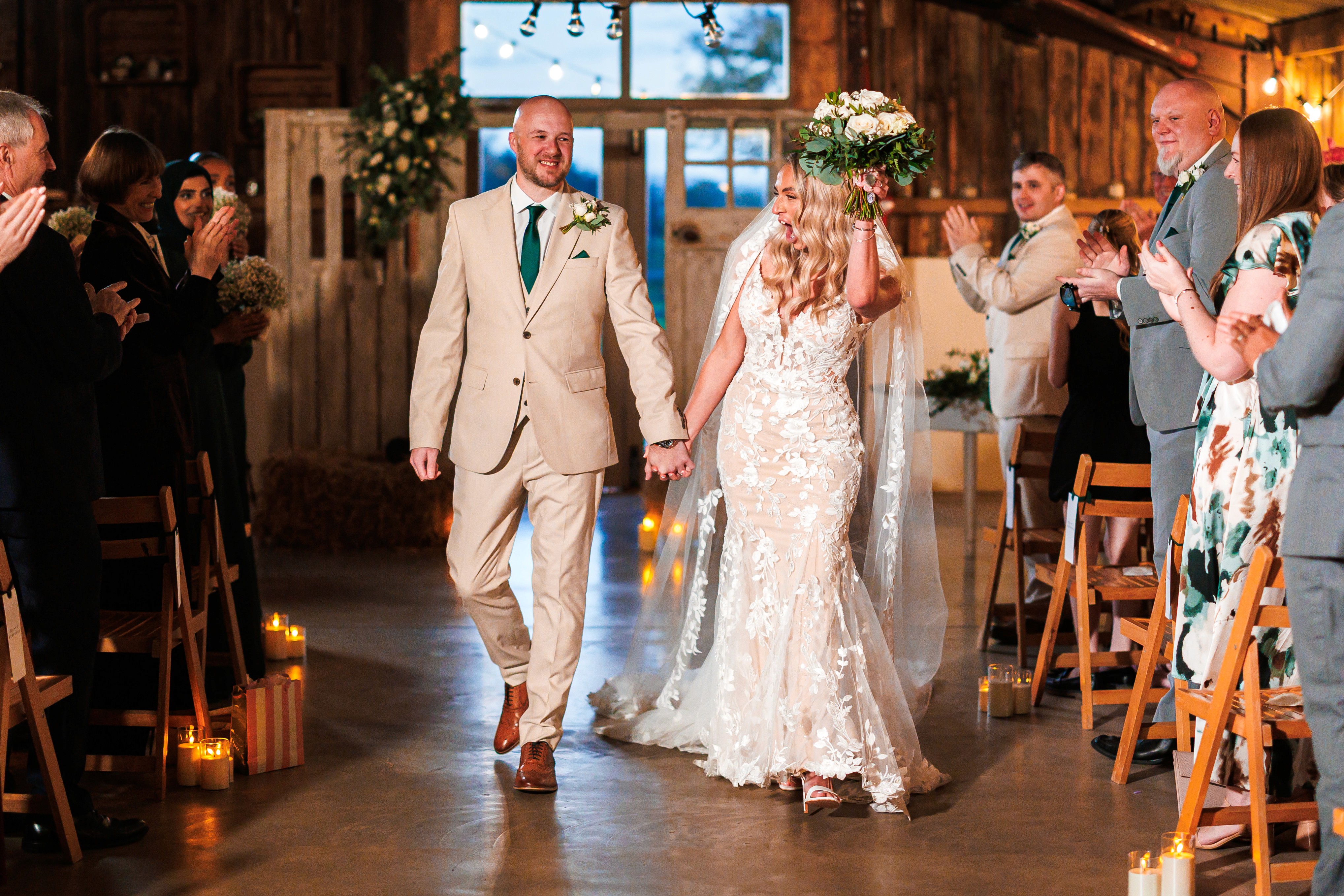 Nikki and Chris walking back down the aisle as their wedding guests applaud
