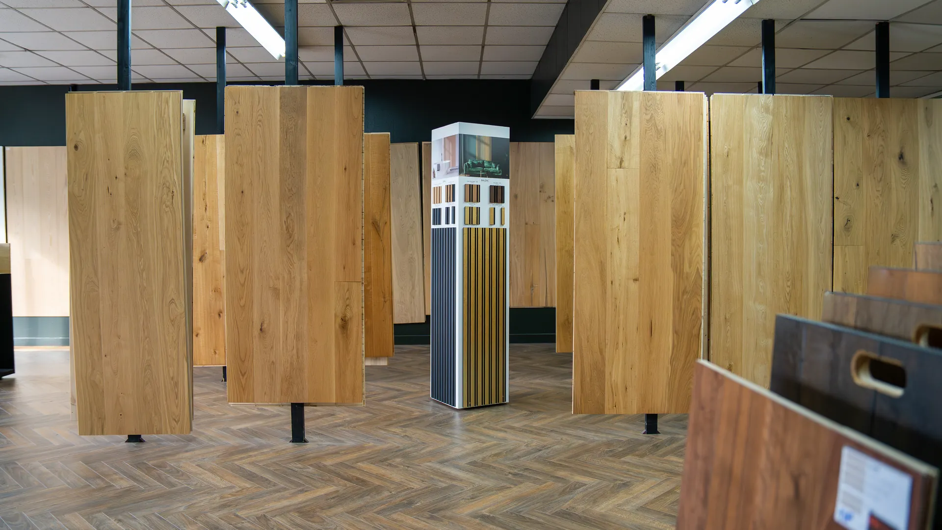 Showroom Aliénor Parquet à Bordeaux : panneaux de parquet chêne exposés sur un sol en point de Hongrie