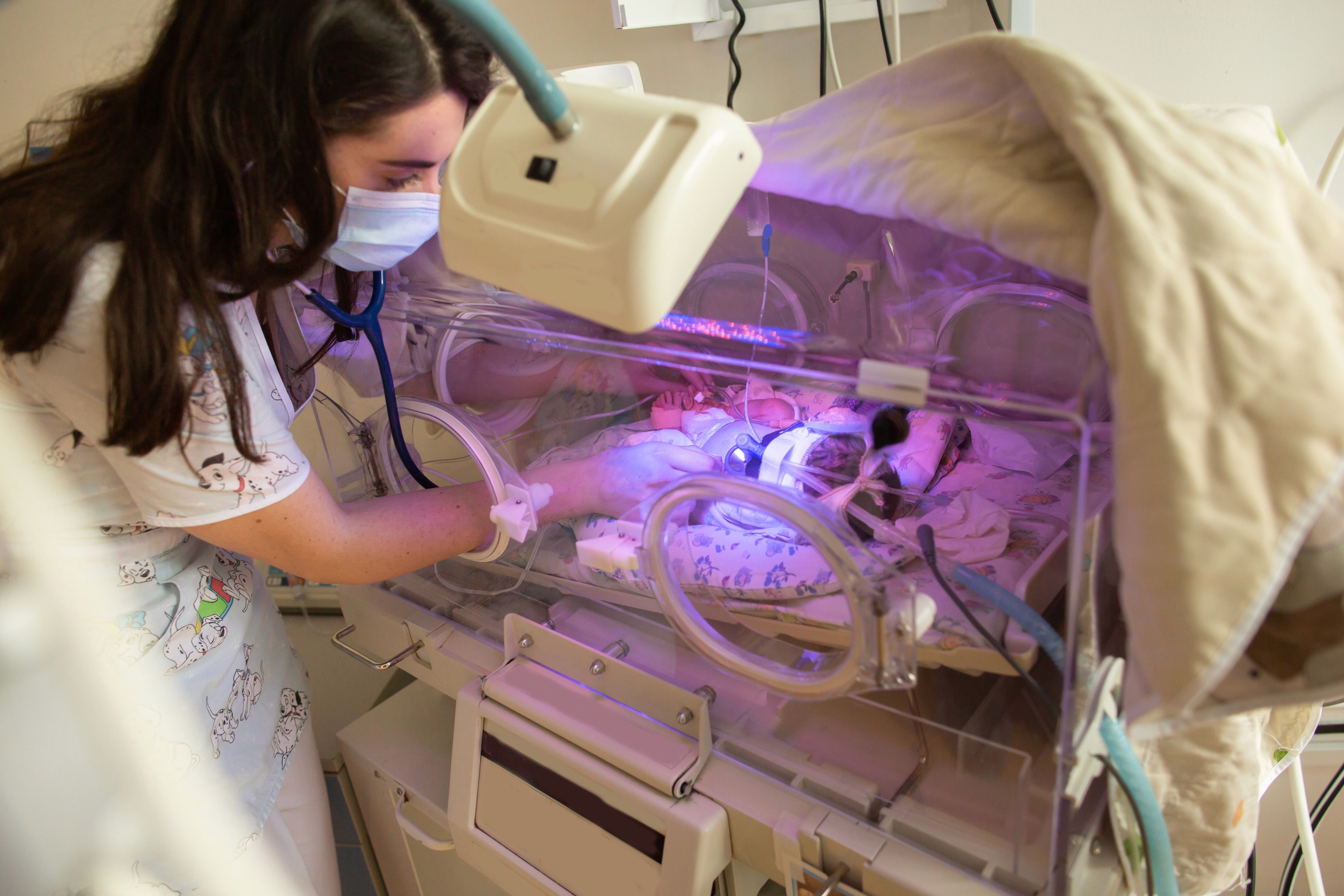 mother spending time in the NICU with her baby who is in an incubator