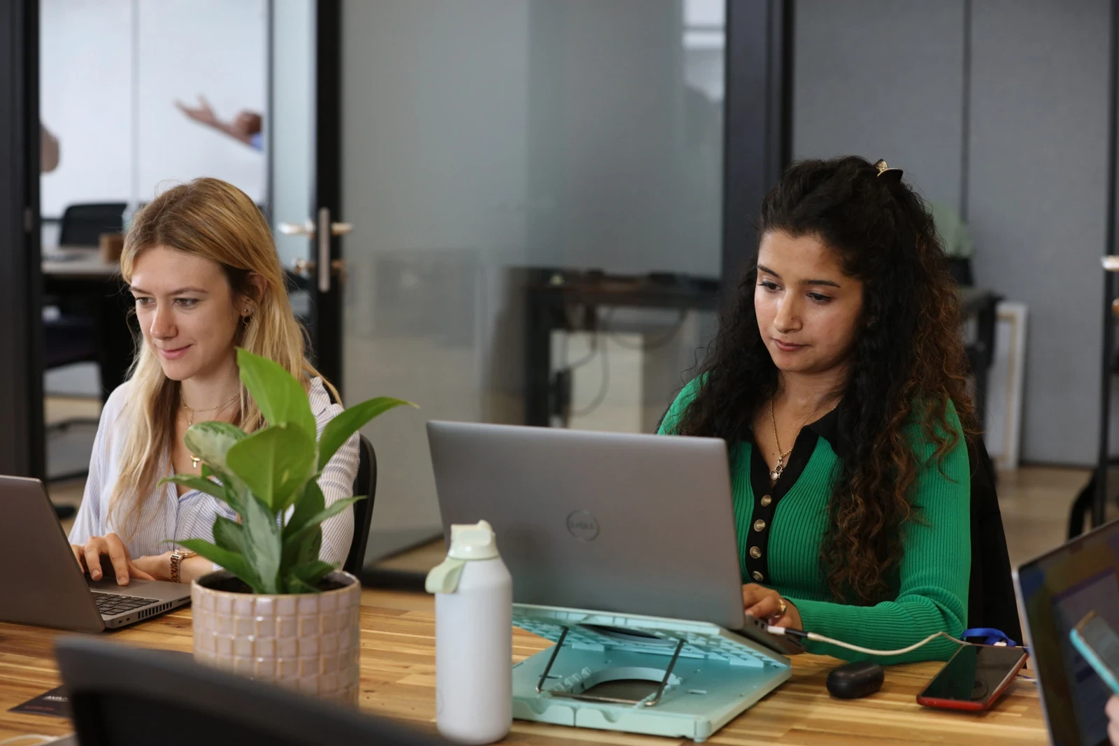 2 young professionals working together smiling at a desk