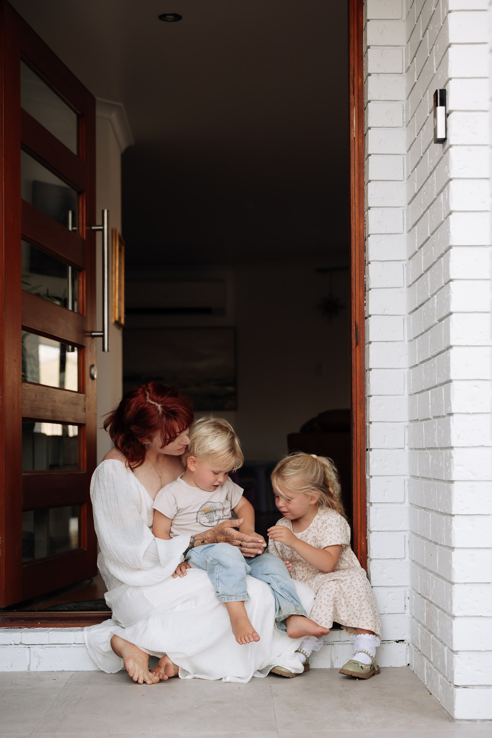 Mackay family photographer capturing mum and children connection at home entrance