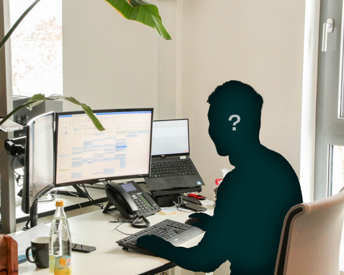 Eine Person sitzt am Schreibtisch. Sie ist unkenntlich gemacht und hat ein Fragezeichen über dem Kopf.