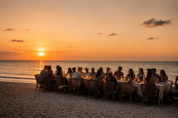 Sunset dinner by the sea at Nômade Holbox, Holbox Mexico, with long table, candles and seated guests