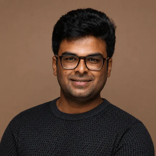 Man with dark hair and glasses wearing a dark knit sweater against a brown background.