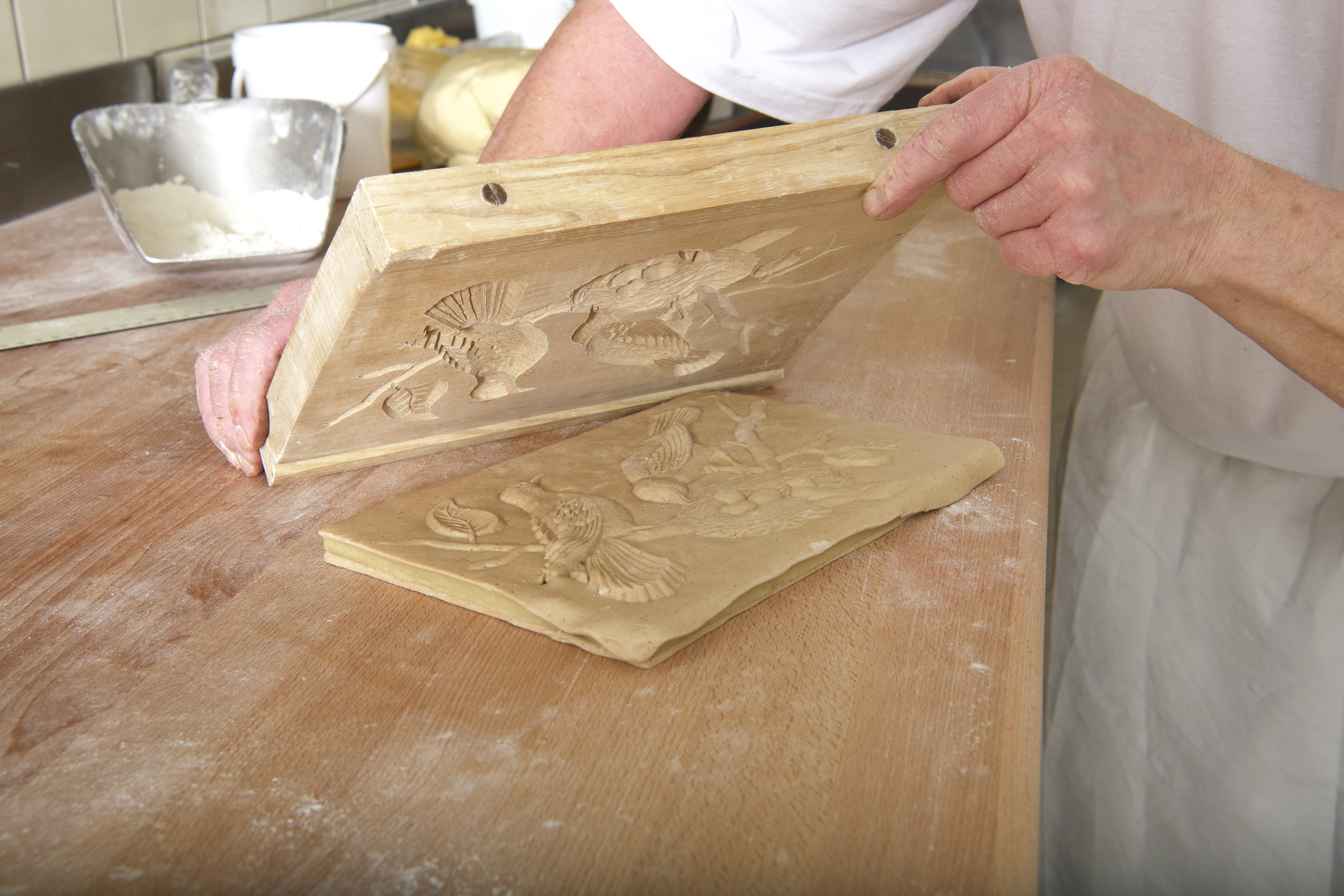 Teig wird mit geschnitztem Holzmodel geprägt für Modelbiber in der Bäckerei Hörnli Hemberg