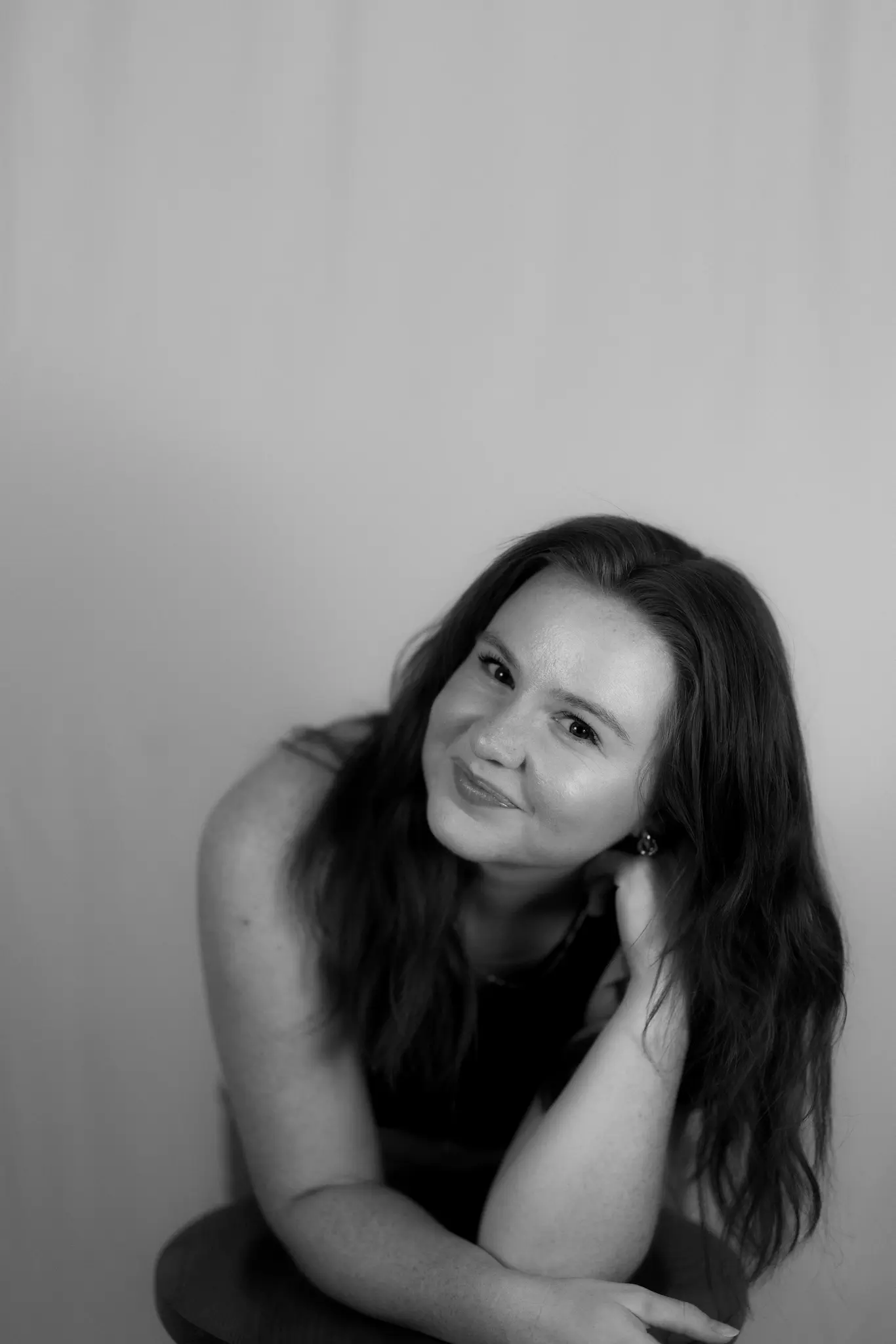 Black-and-white portrait of a smiling Meridian Studio team member with long hair
