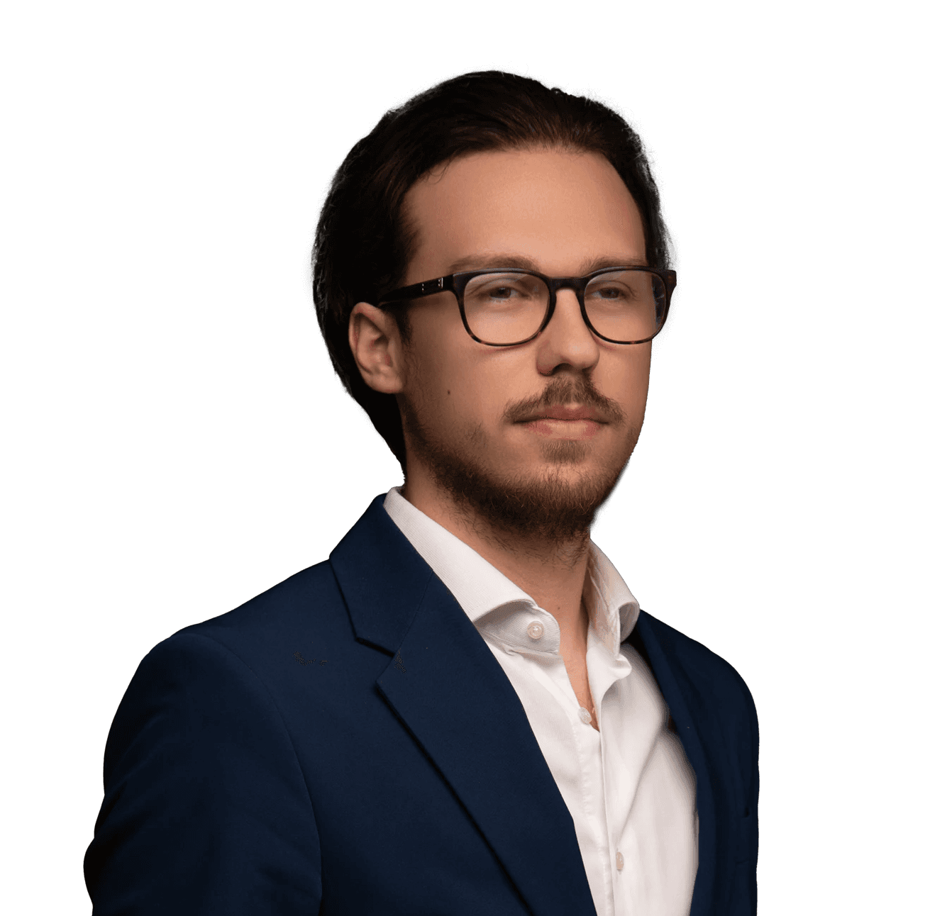 Szemüveges, iatal férfi hátrafésült hajjal, fehér ingben és fekete zakóban, narancssárga háttér előtt.