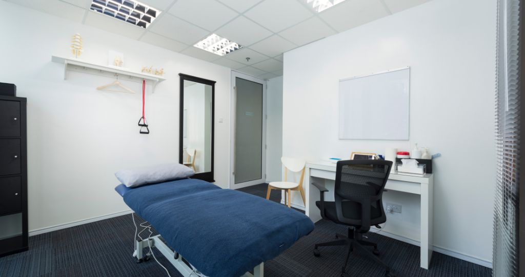 Interior of a chiropractic clinic with an examination bed and desk