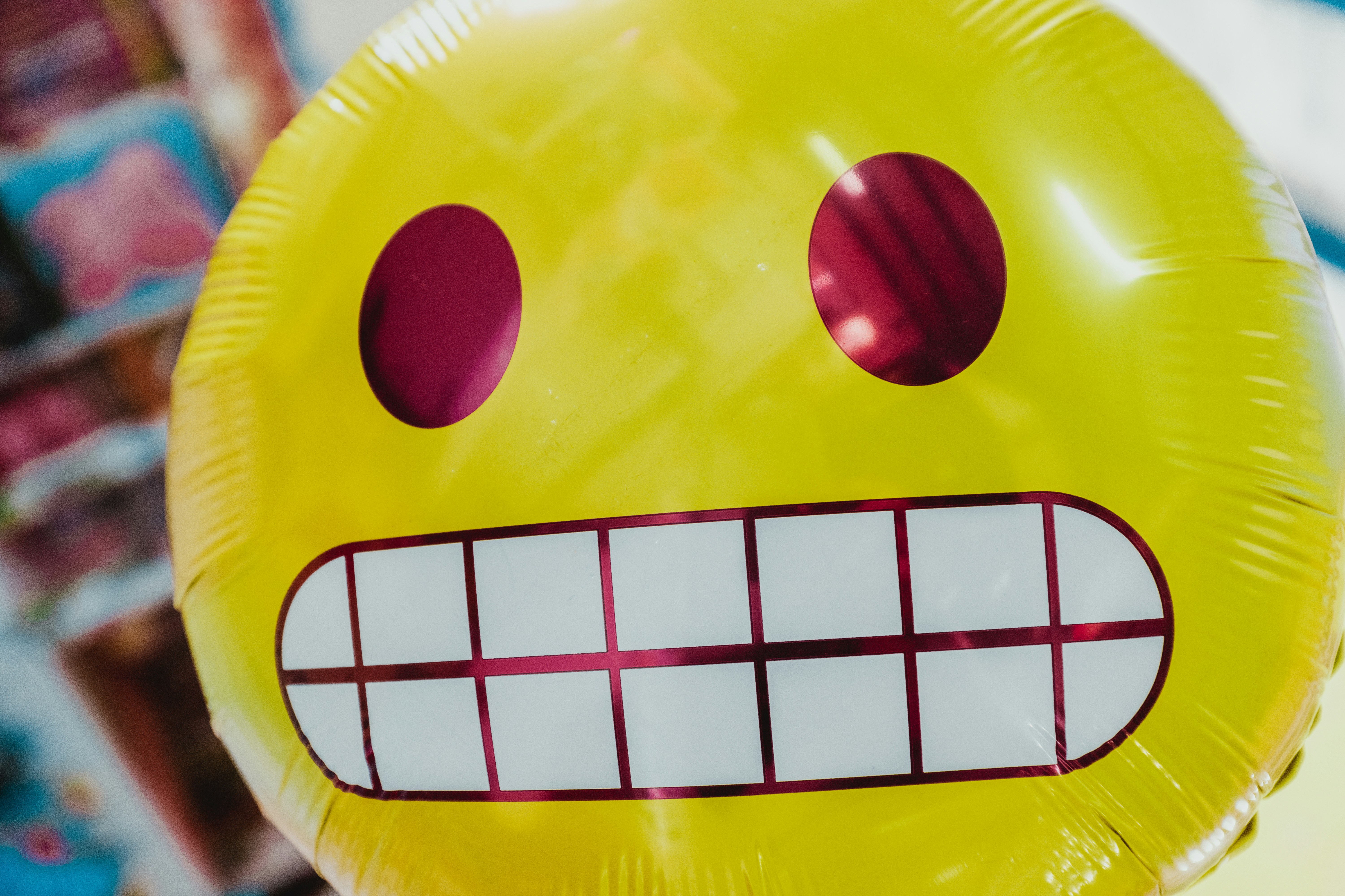 yellow inflatable smiling emoji balloon in focus photography