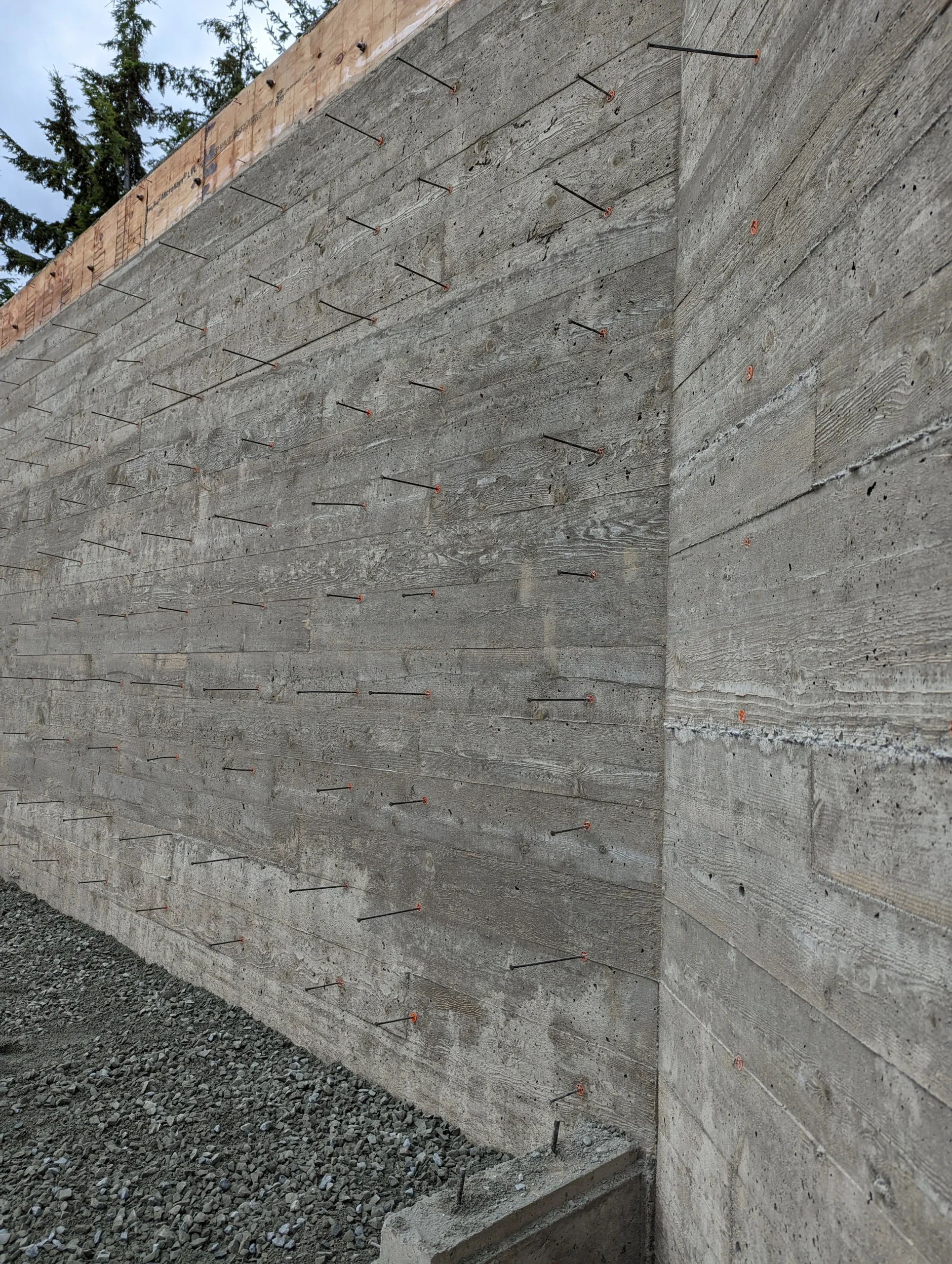 Modern two-story home with large glass windows, warmly lit interiors, and a balcony. Surrounded by trees and a manicured lawn at dusk. Cozy ambiance.