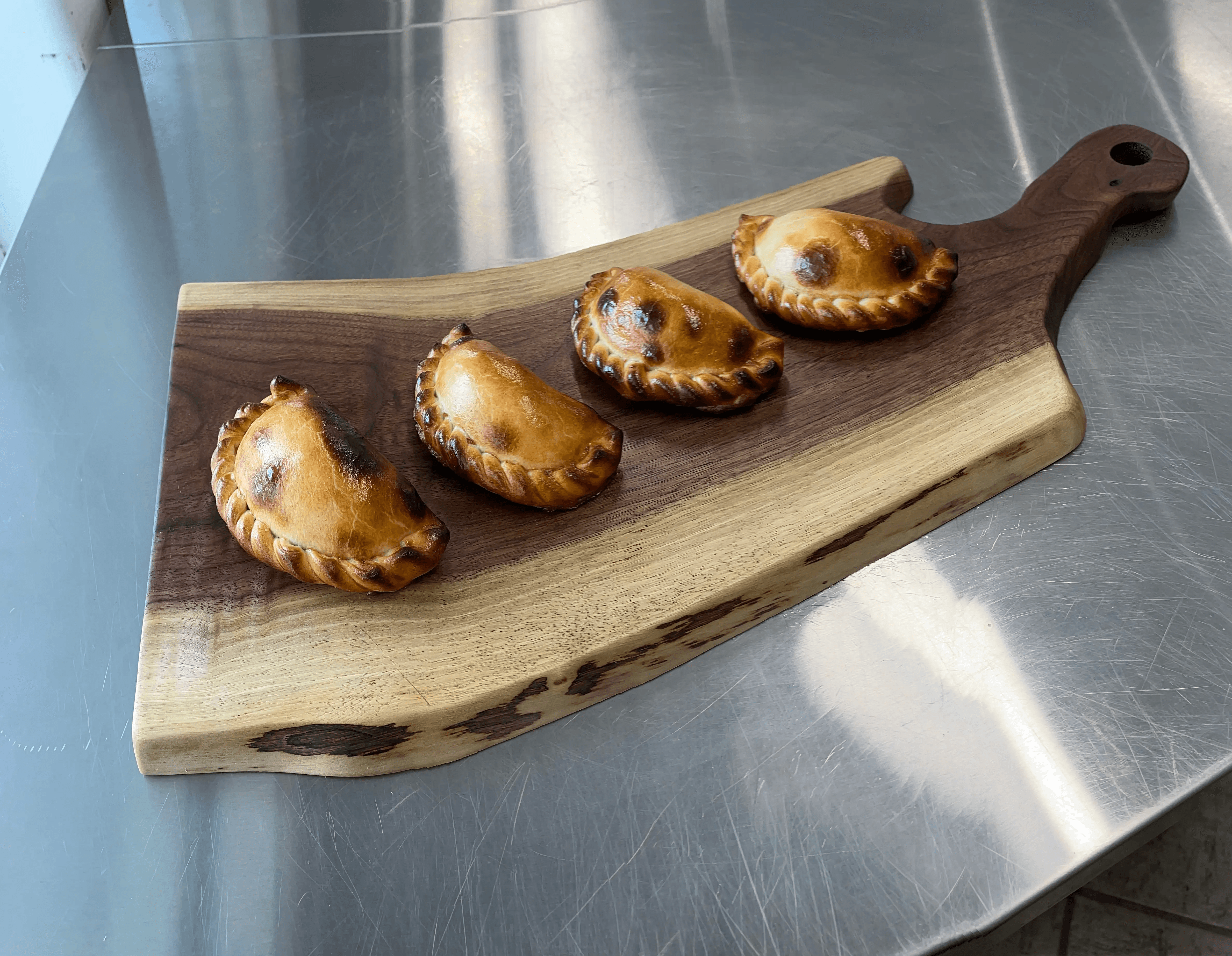 Artisan empanadas served on a wooden board by Scorpion Chef Vancouver Island