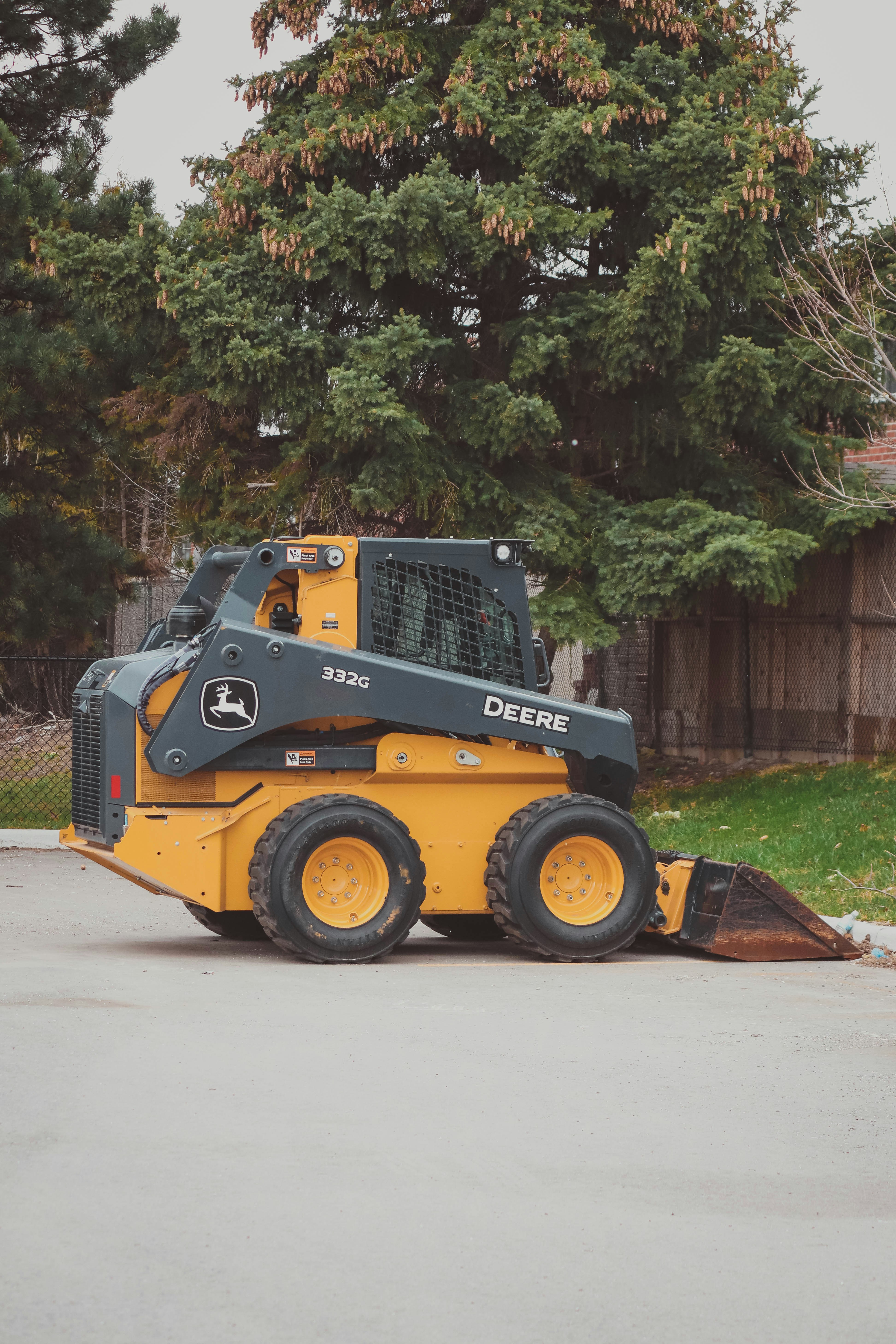 man in orange and black vest wearing white helmet holding yellow and black power tool