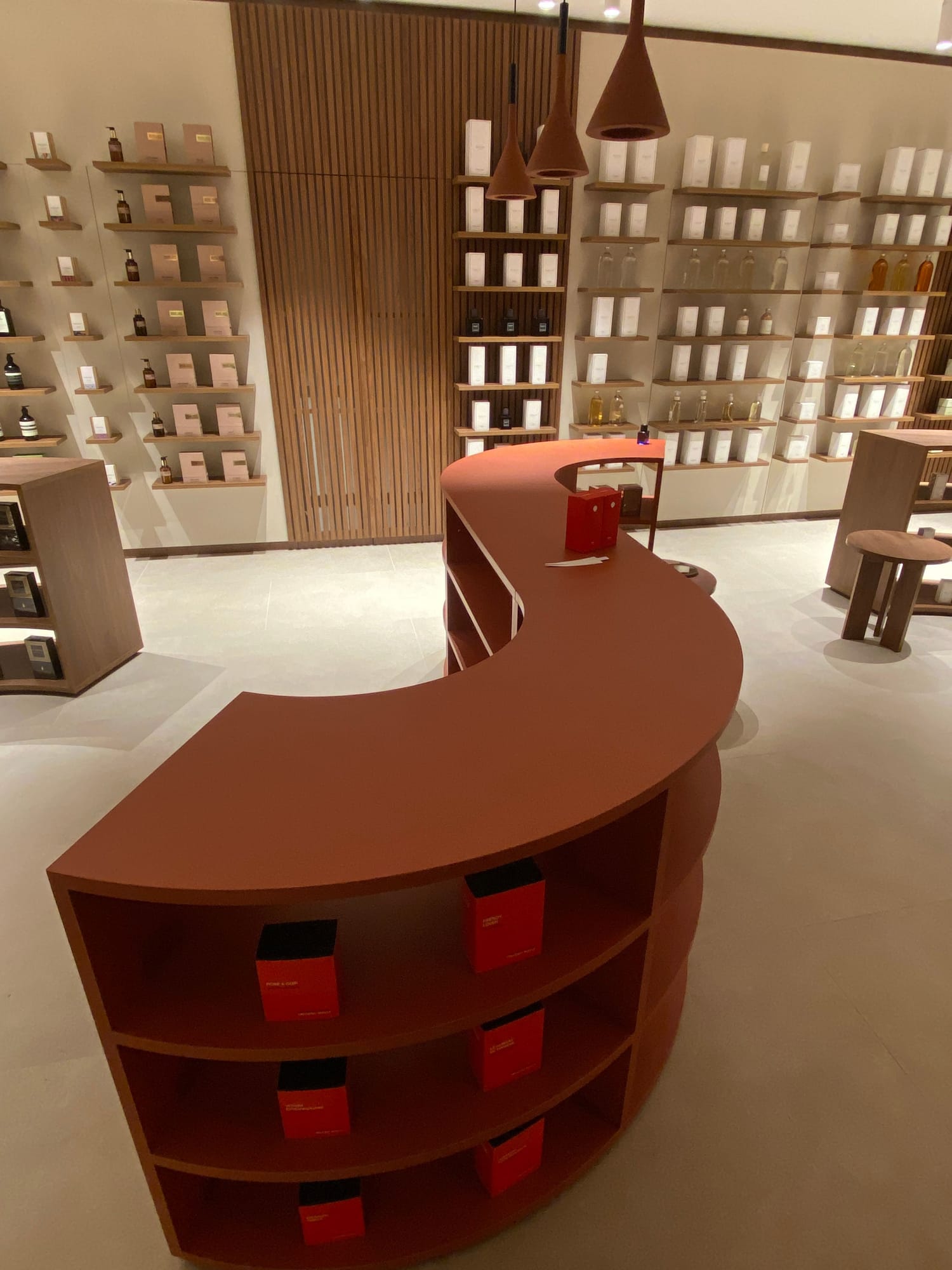 Curved terracotta counter with walnut shelving
