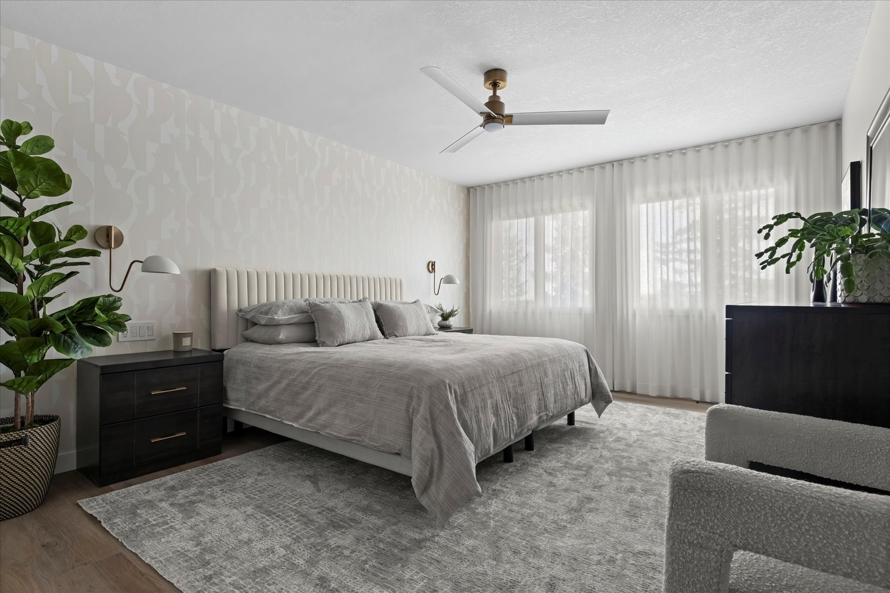 Strathcona primary bedroom after: upholstered bed, textured feature wall and sheer drapery