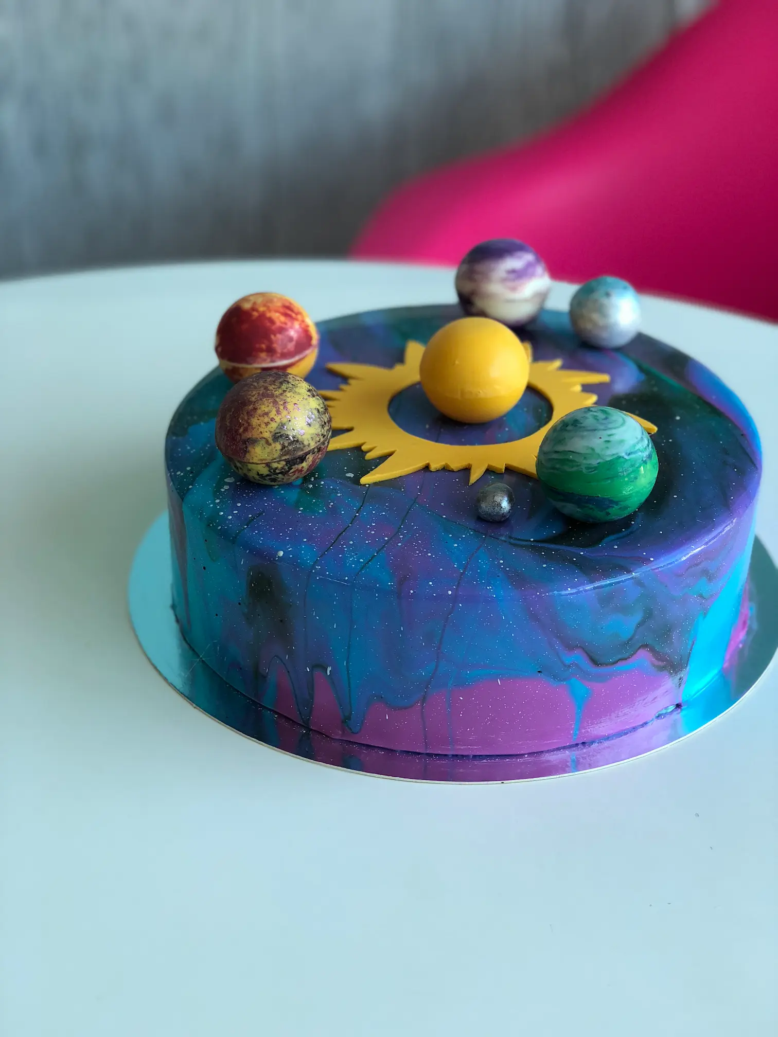 Galaxy-themed blue and purple marble cake with planet decorations and astronaut topper