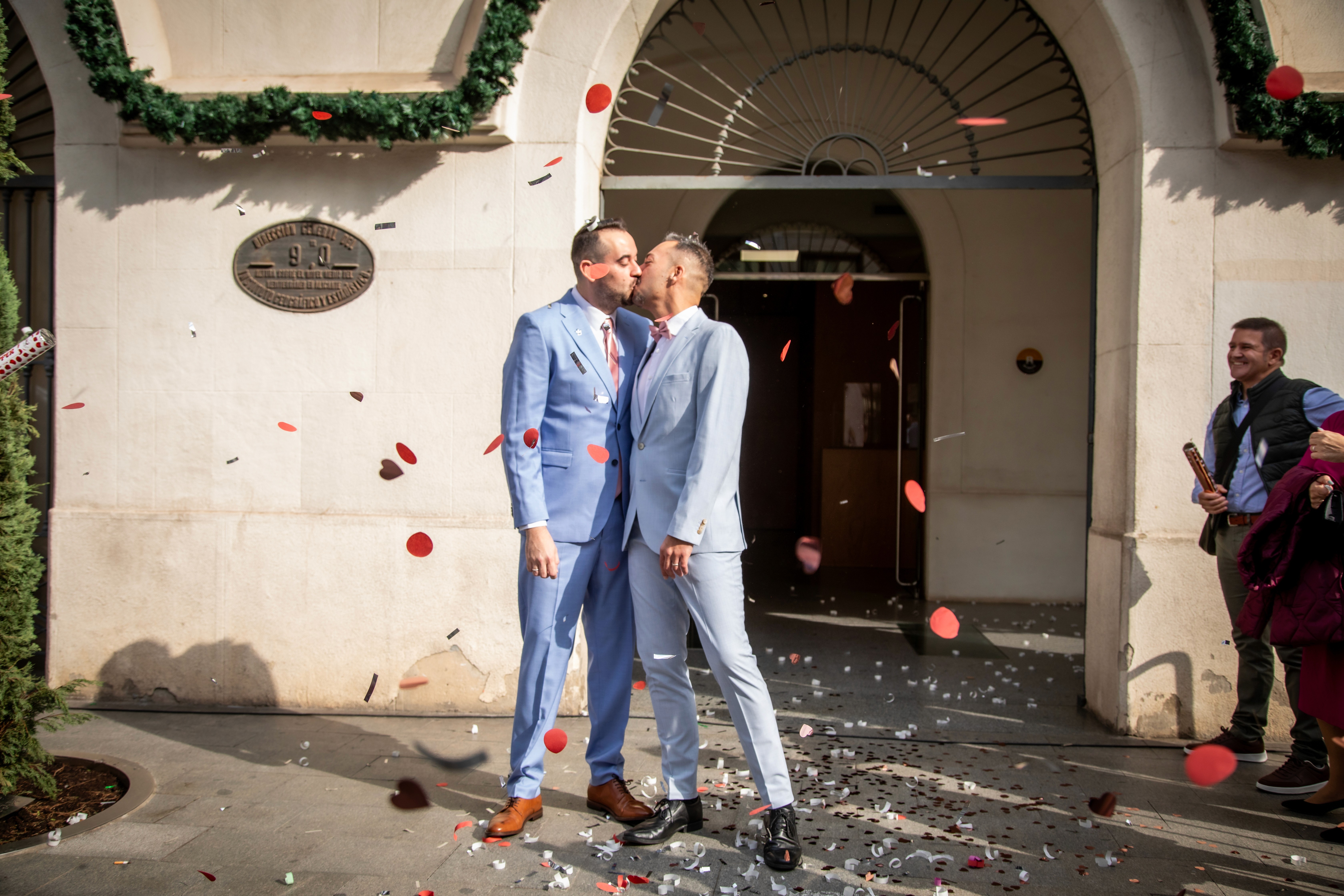 Sesión de boda. Pareja rodeada de petalos dandose un beso