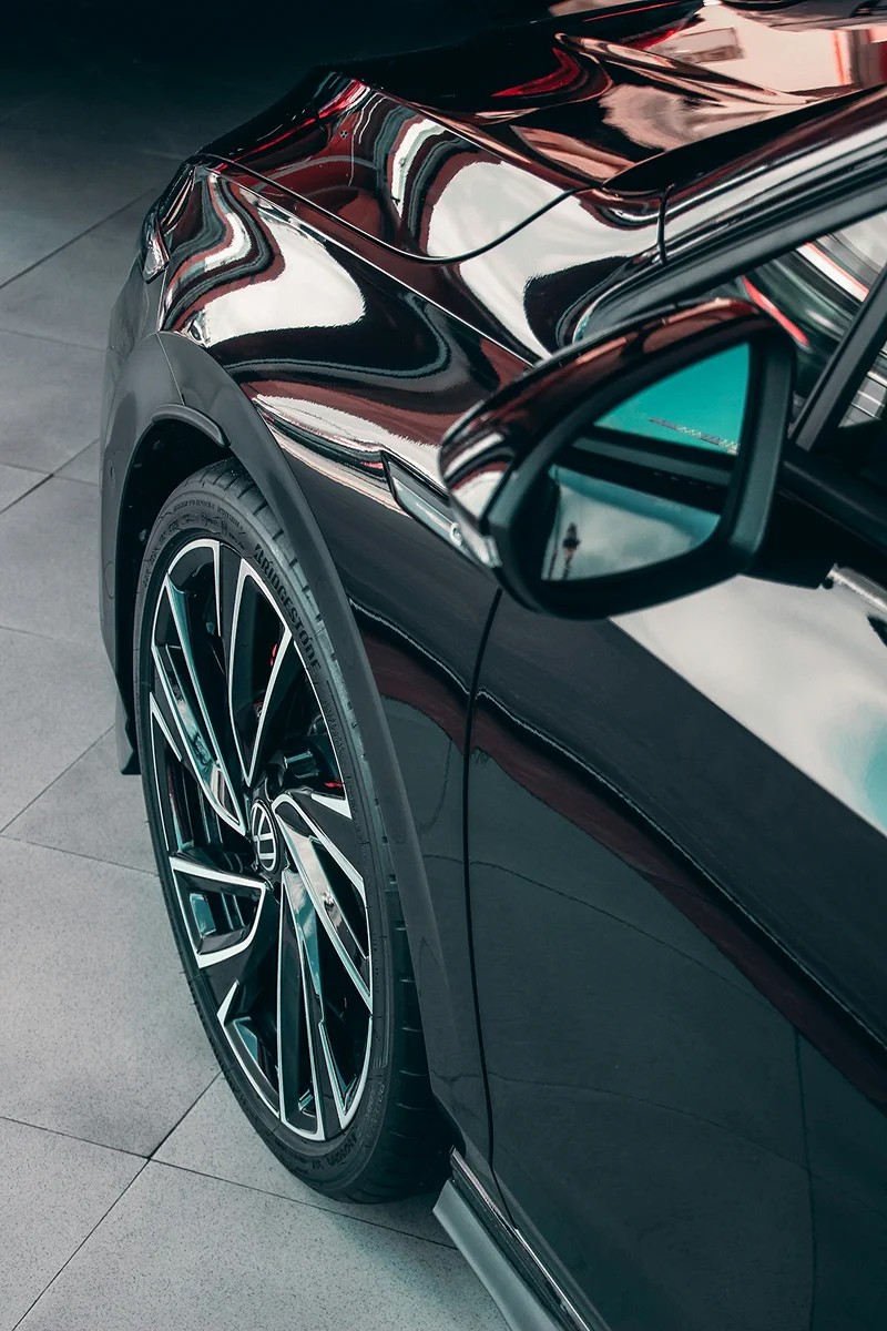 Glossy black vehicle surface showing enhanced shine and paint protection after ceramic coating application.