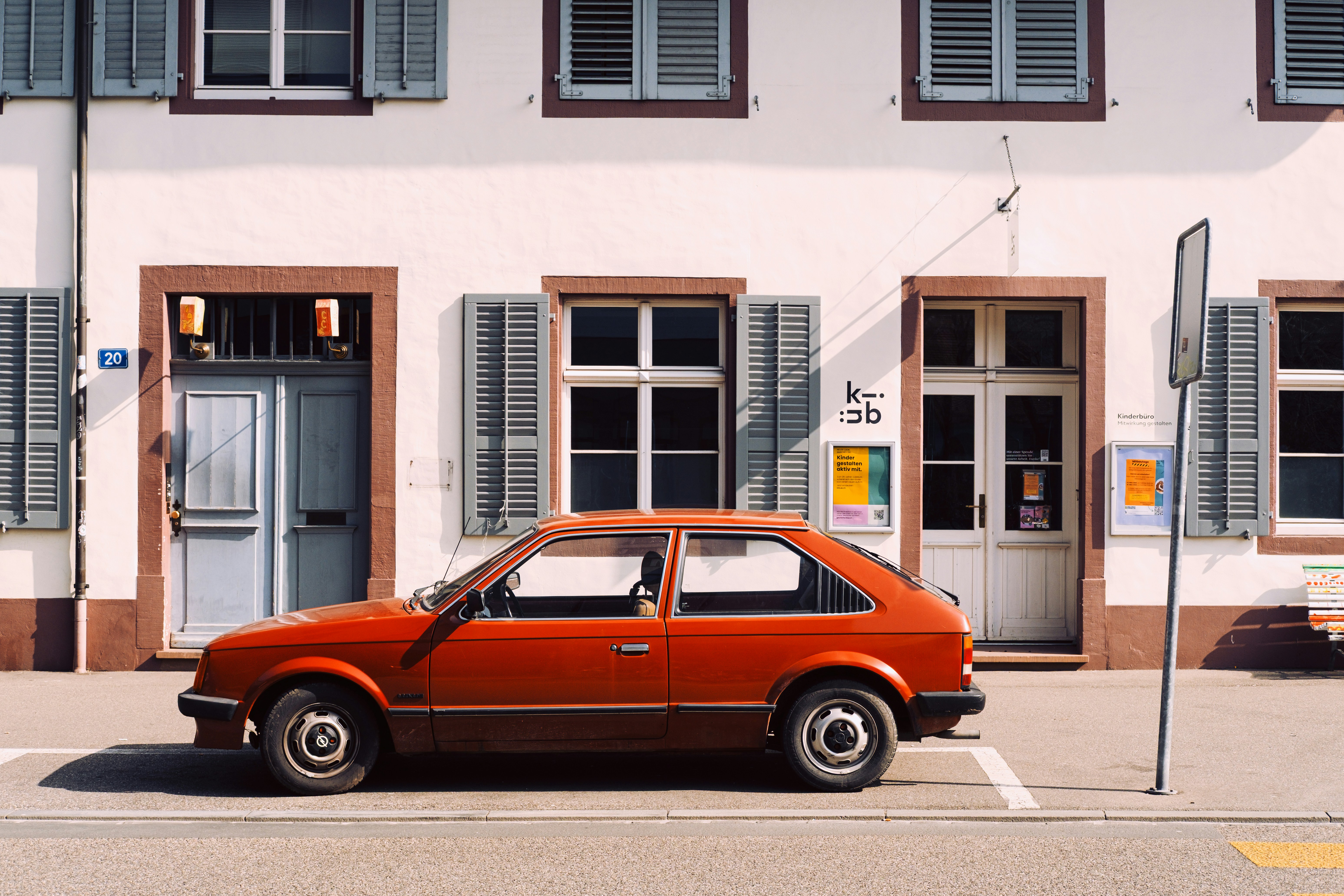 Red vintage car parked in front of a building