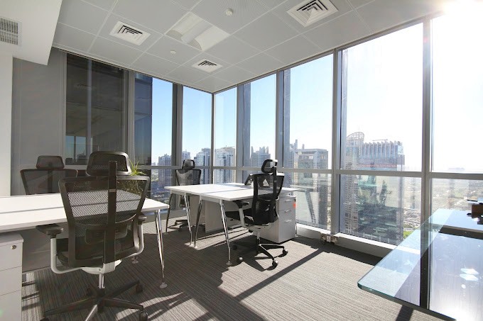 A well-organised desk setup with chairs and tables, perfect for a hot desking workspace by myOffice