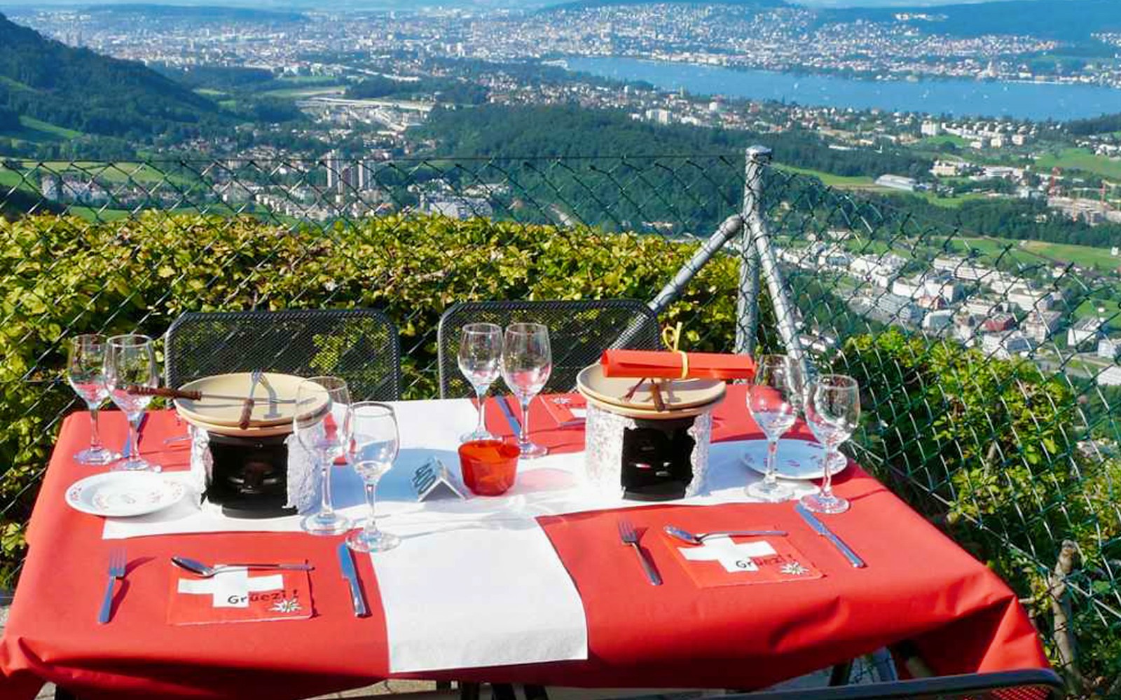 Dinner table with fondue set overlooking Zürich cityscape.