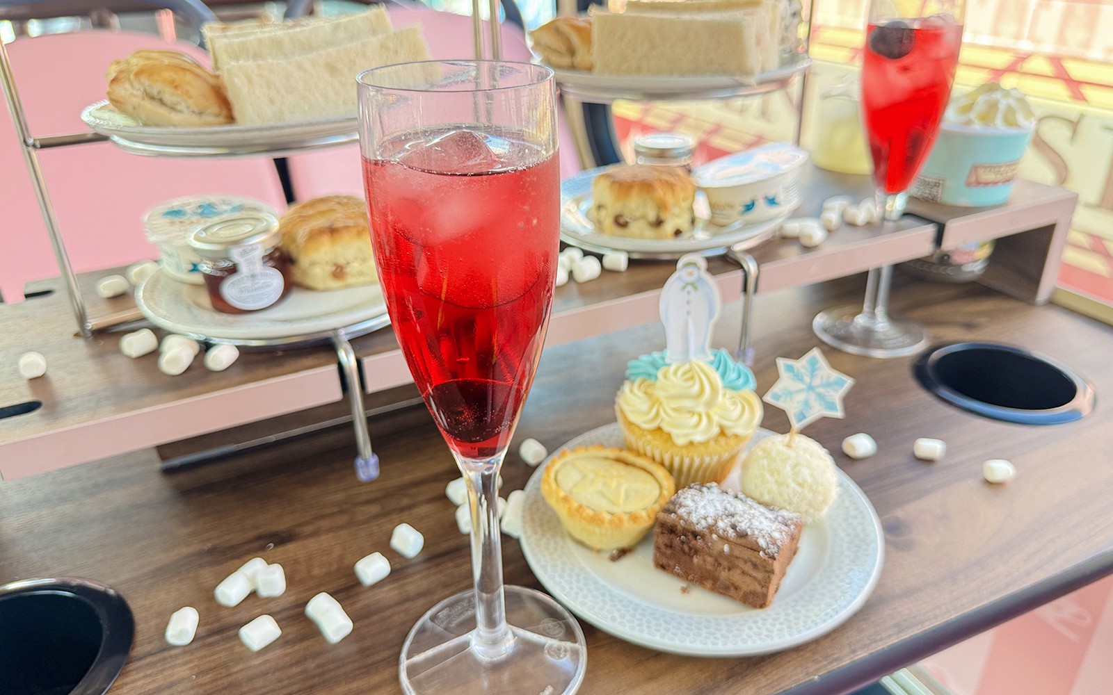 雪人官方下午茶巴士上的下午茶點心，包括司康、三明治和糕點。