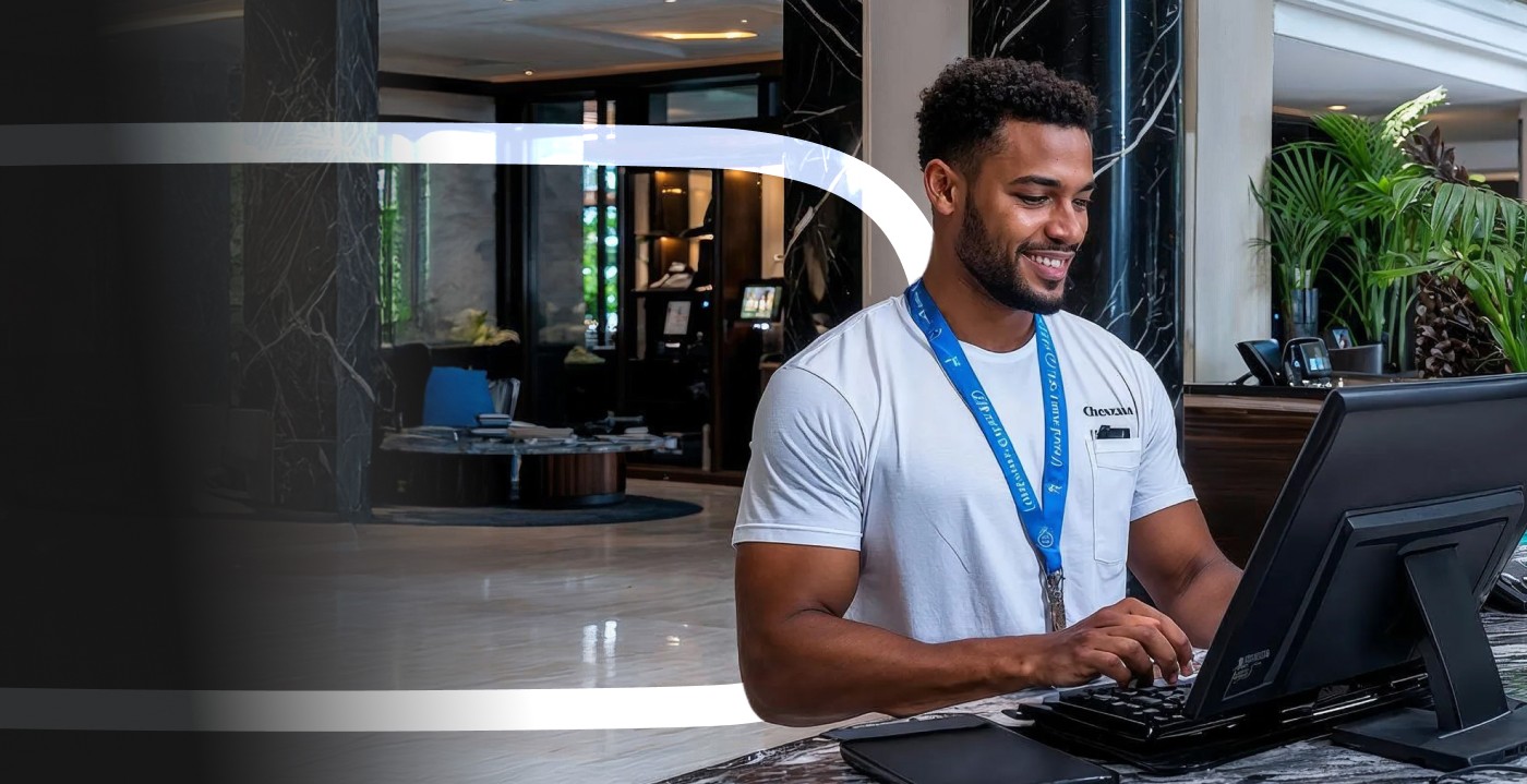 Réceptionniste d'hôtel souriant travaillant sur son poste à l'accueil