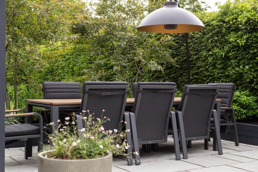 Modern scandi-style garden with a cedar clad garden room, two sun loungers, lush greenery, a paved walkway, raised timber decking, barrel sauna and swing gate. 