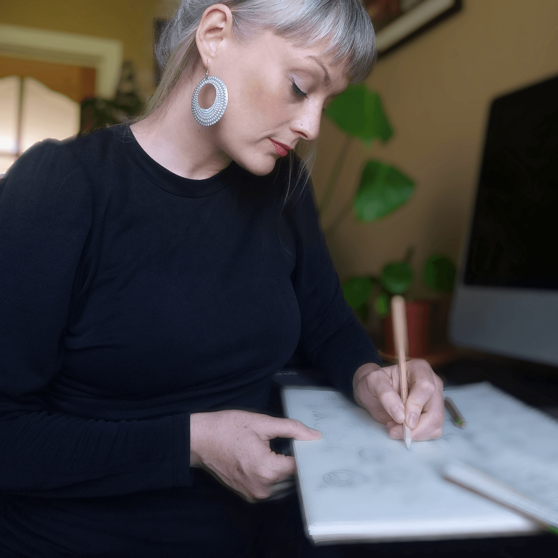 woman using MacBook and wearing yellow headphones